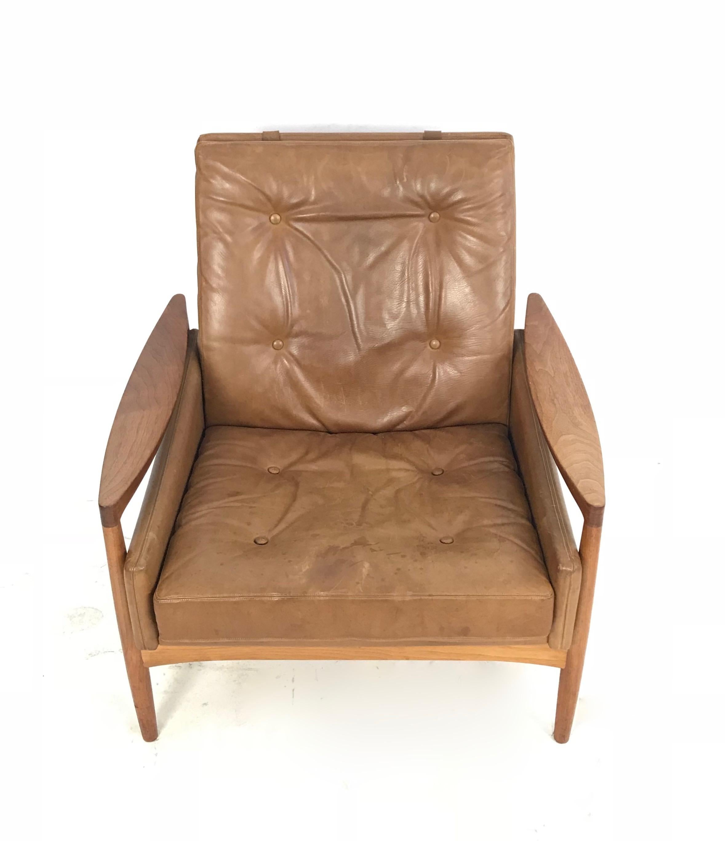 This is a sleek and unusual Danish modern wood and brown leather accent chair by Erik Worts, circa 1960.