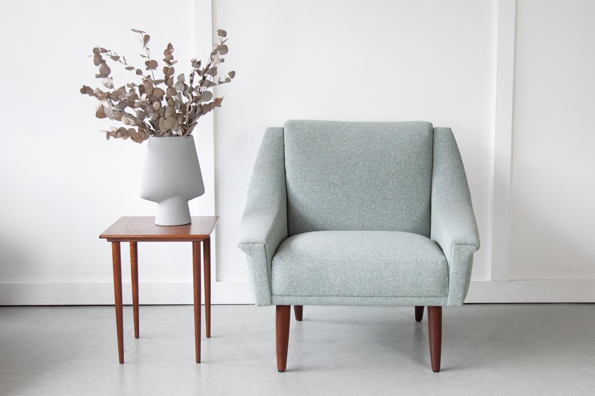 A stunning Danish armchair, designed by Georg Thams for Vejen Polstermøbelfabrik. With lovely splayed teak legs and sweeping armrests with the typically mid-century winged detail, it is a wonderful example this era of furniture design. Newly