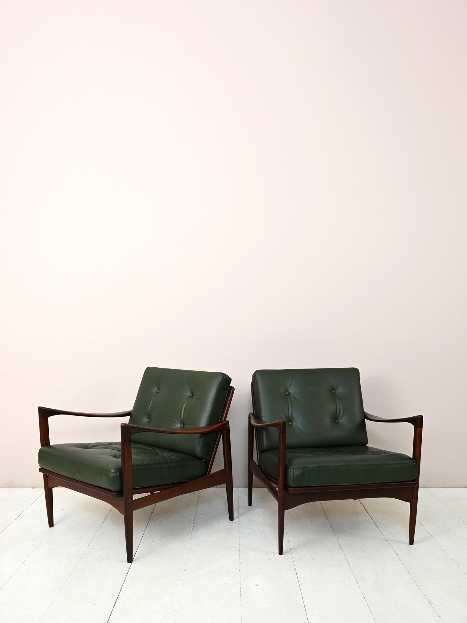 Pair of armchairs model Kandidaten for Ope.

Iconic Danish design object designed by Ib Kofod in the 1960s.
The solid teak wood frame has essential and refined lines. The greenish-colored cushions are vintage originals and in good