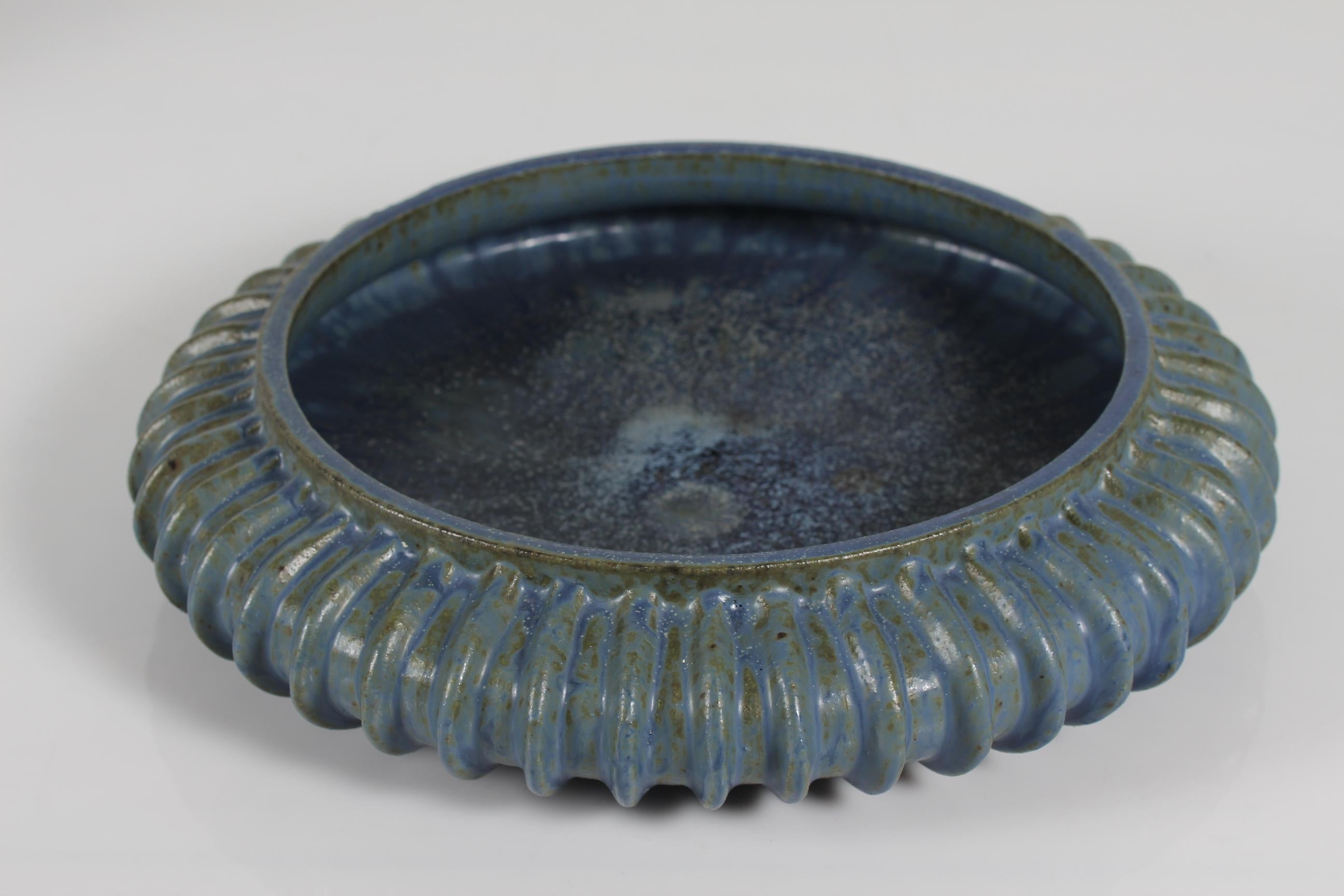Huge Art Deco stoneware bowl from the 1930s model no. 154.
Designed by the Danish ceramist Arne Bang (1901-1983).

The bowl is decorated with glaze in shades of blue with green elements.
The outside of the bowl has a modeled pattern of grooves