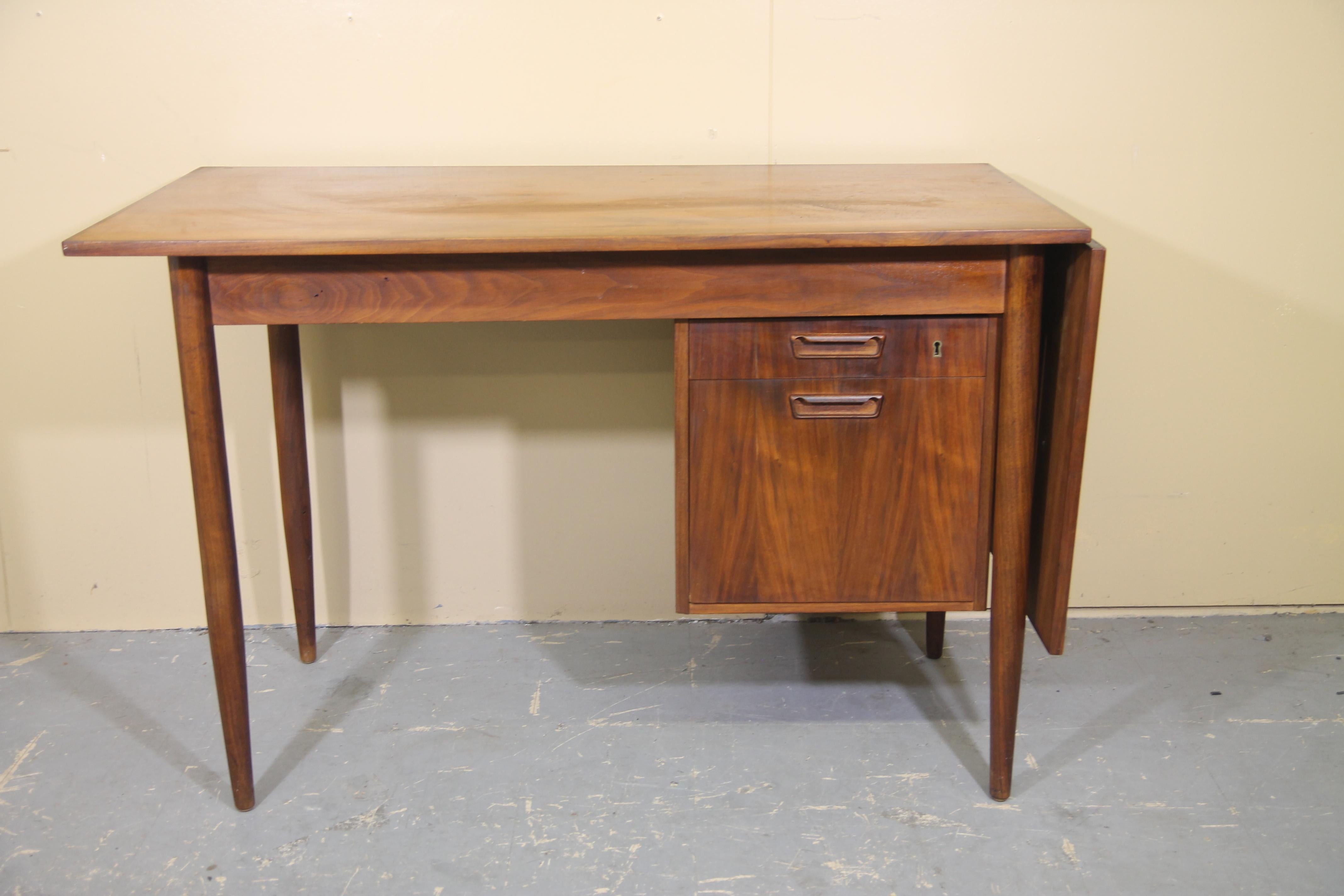 Nice 1960s desk attributed to Arner Vodder. This desk has a drop leaf top when opened goes from 46 inches to 64.75. File cabinet also slides from side to side. A nice classic versatile desk ready for you home office.