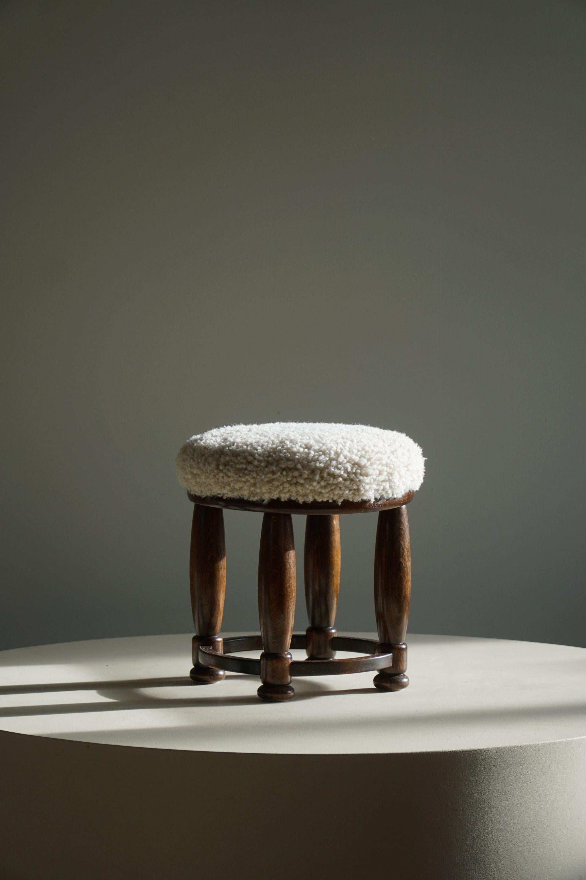 A lovely round Art Deco stool in beech and reupholstered seat in a great quality shearling lambswool. Made by a Danish cabinetmaker in the 1940s.

This nice footstool will fit in many interior styles. A modern, Scandivinavian, Art Deco interior or a