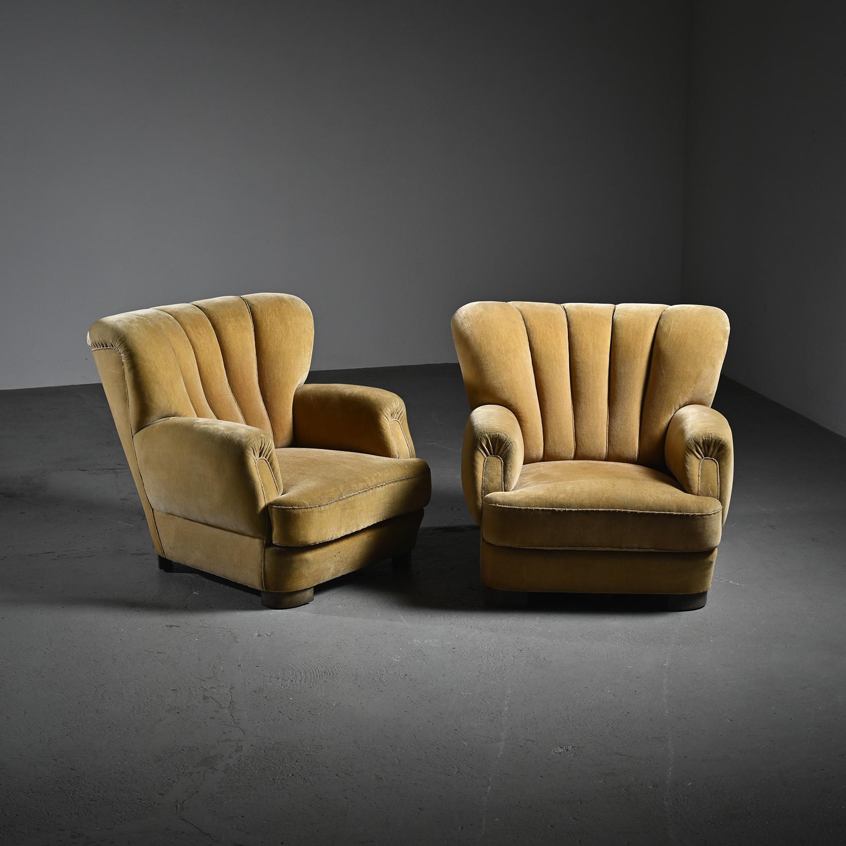 
Pair of Art Deco armchairs, Danish work from the 1940s.

These two generously proportioned armchairs embody the elegance of Danish furniture from the 1940s, in the spirit of Fritz Hansen. With their fan-shaped tufted backrests, they are designed to
