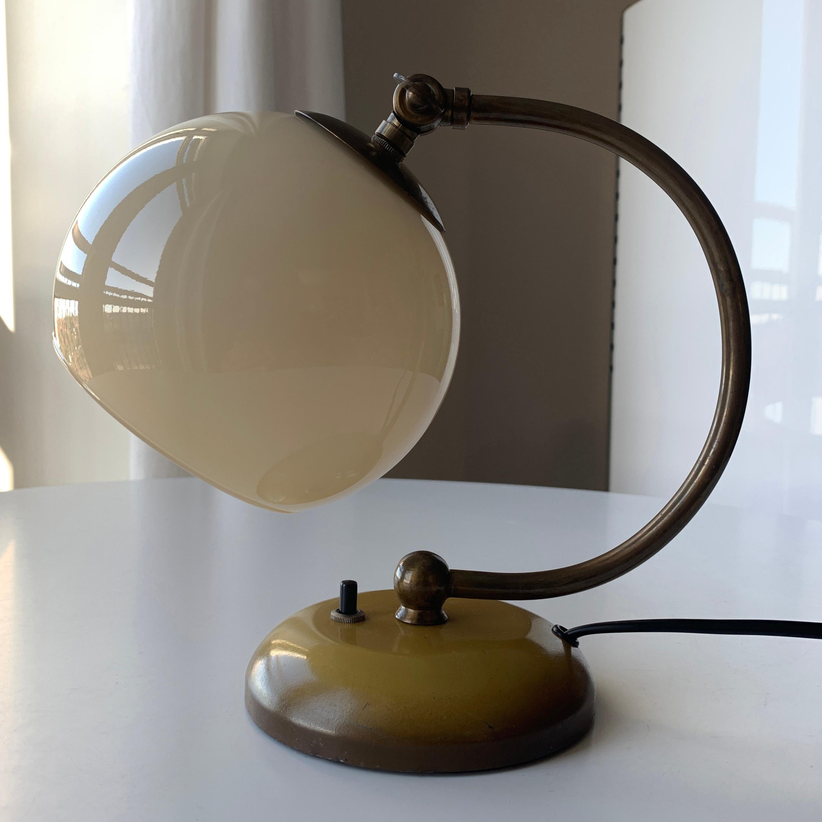 Danish Art Deco bedside table lamp manufactured by Danish company Fog & Mørup in the period of 1920s-1950s. A Fog & Mørup model based on the same design that can stand on table or hang on wall. A curved neck with an adjustable shade holder to set