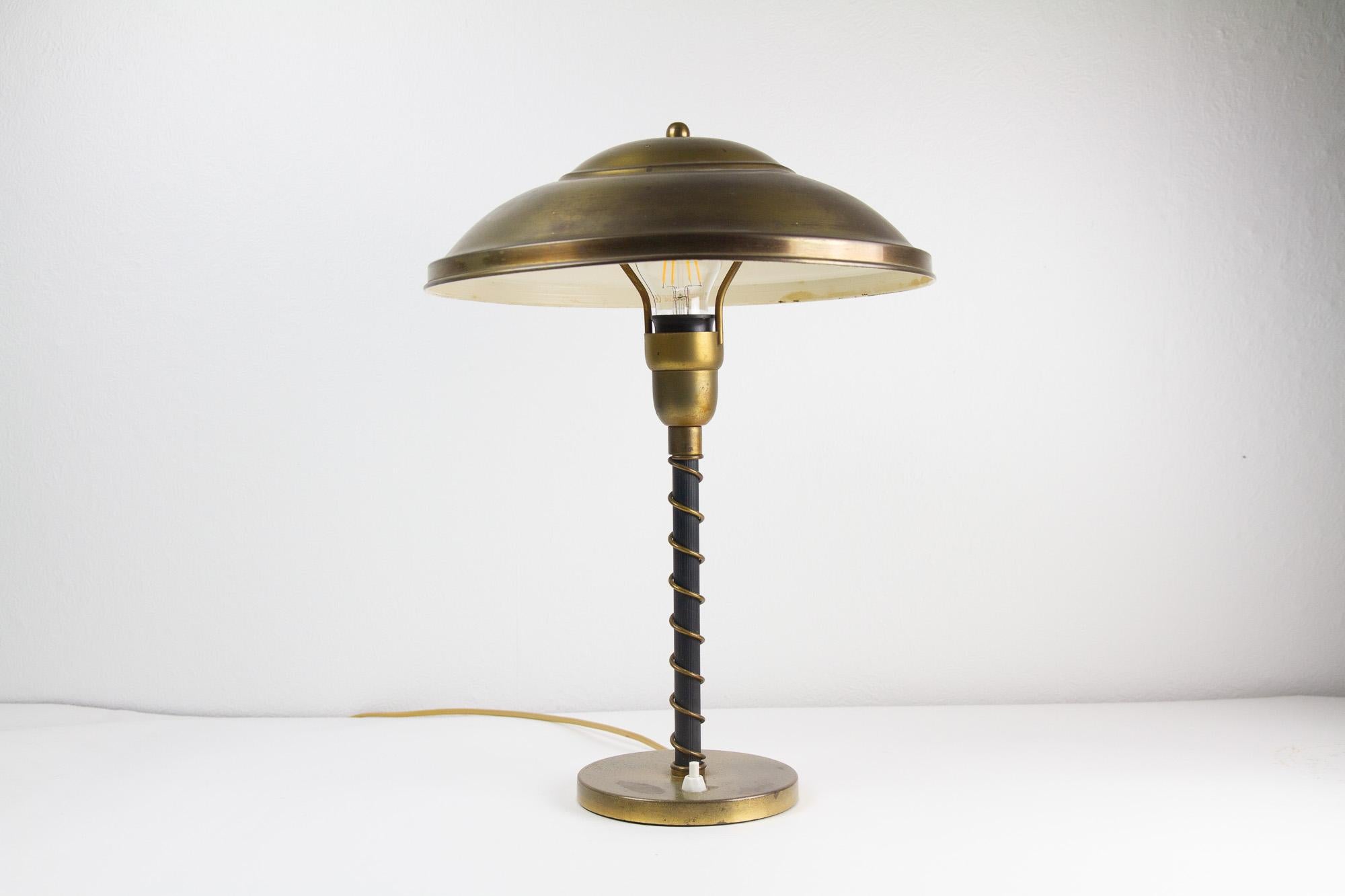 Danish Art Deco Brass Table Lamp, 1930s.
Dome brass shade and base with switch. Black stem with twisted brass wire.
Beautiful patina on brass parts.
E26/27 socket. Working order.
Good original condition.