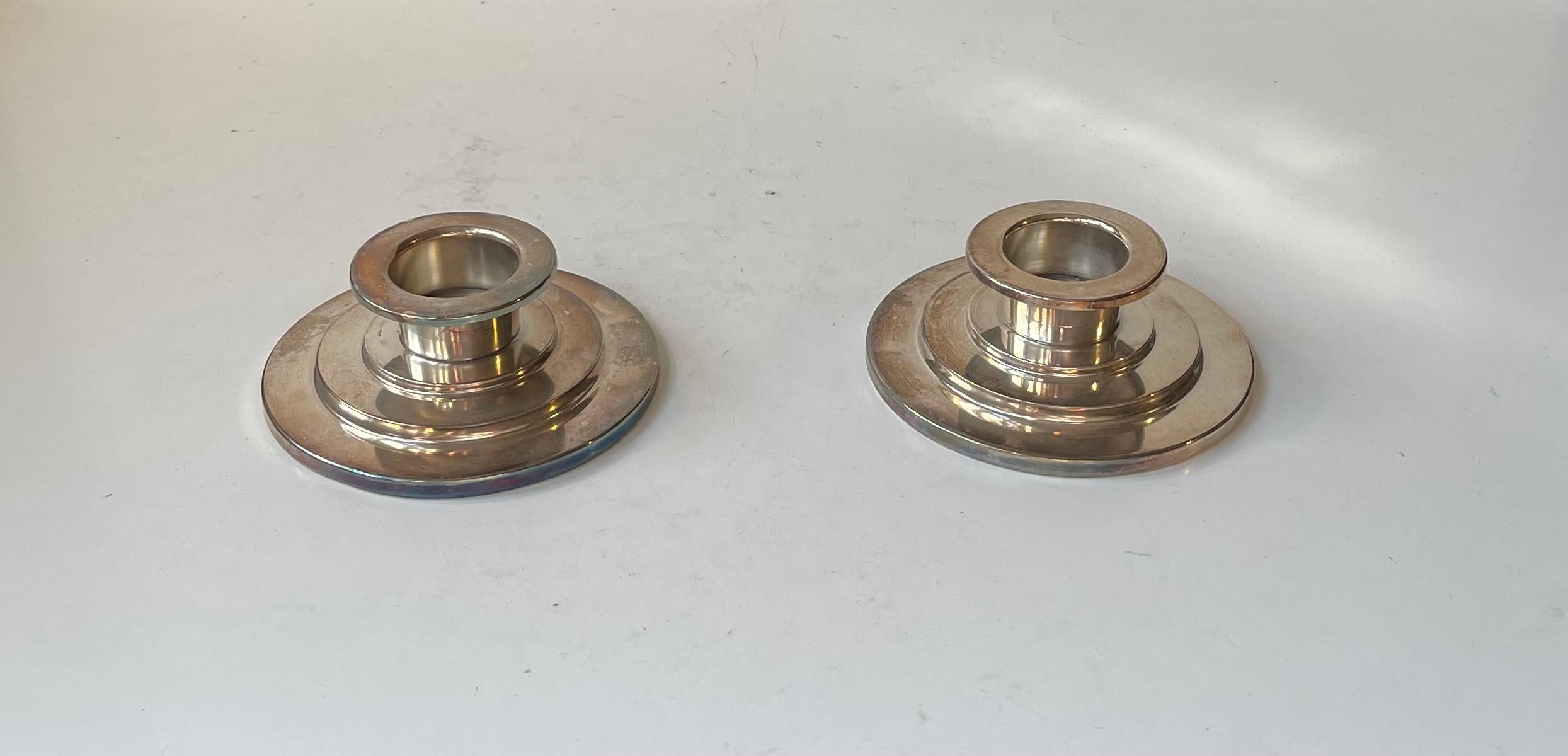 Elegant pair of low candlesticks for block- or tea light candles. Executed in silver plated metal. Distinct art deco styling with 'stair'ed bases'. Signed TS or JS and the Danish word for silver plate. Denmark circa 1930-40. Similar in style to