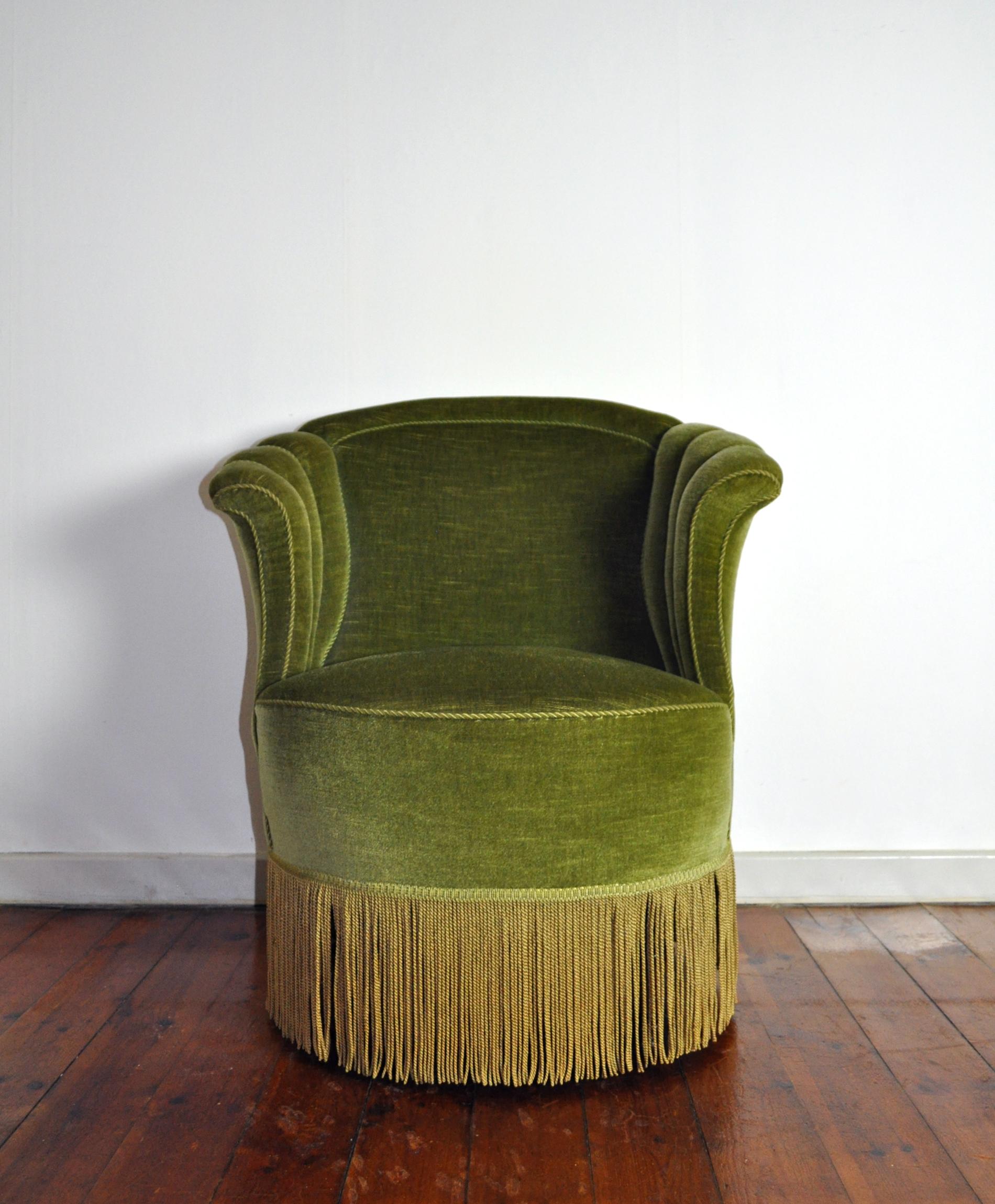 Voluptuous Art Deco chair executed with wooden legs, green velvet and fringes (can be removed). High lined and curved back and backrest.
It shows traits of traditional Victorian furniture yet also has a contemporary Art Deco touch.
Excellent