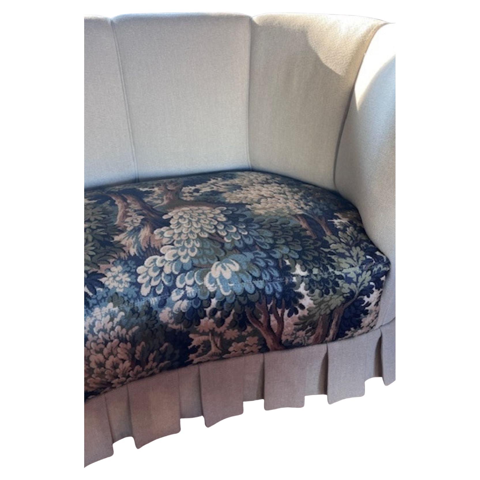 Tissu nouvellement tapissé avec jupe. Cette pièce art déco incurvée, vers 1950, est parfaite pour tous ceux qui souhaitent apporter du charme à leur espace. Il était à l'origine recouvert d'un tissu floral démodé. Nous l'avons donc retapissé avec un