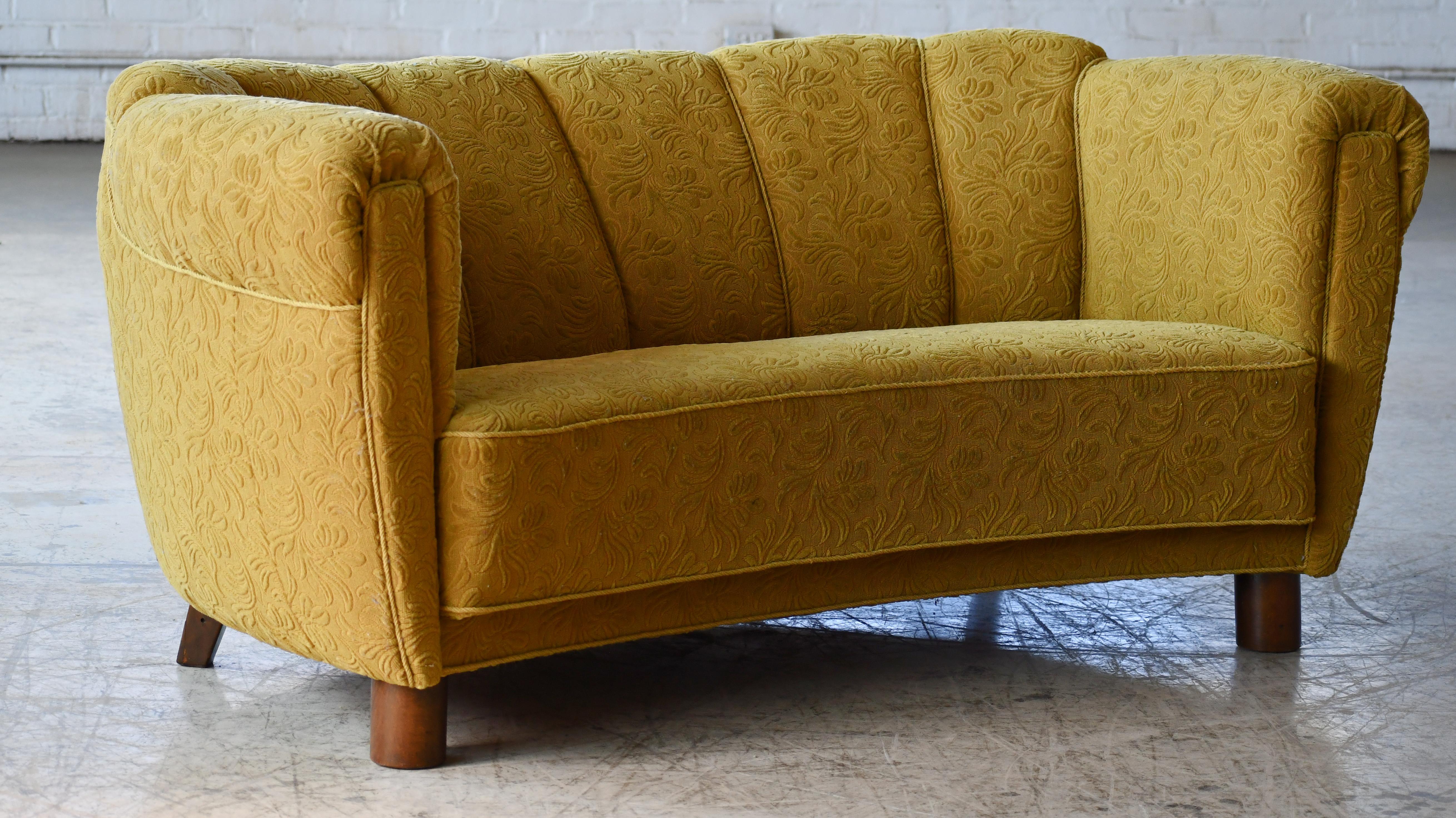 Beautiful Danish curved sofa or Banana sofa as the Danes call them. This sofa is a bit unusual compared to others from the era as it has a raised backrest a detail sometimes seen in the Art Deco era. Resting on cylindrical legs in the front. Most
