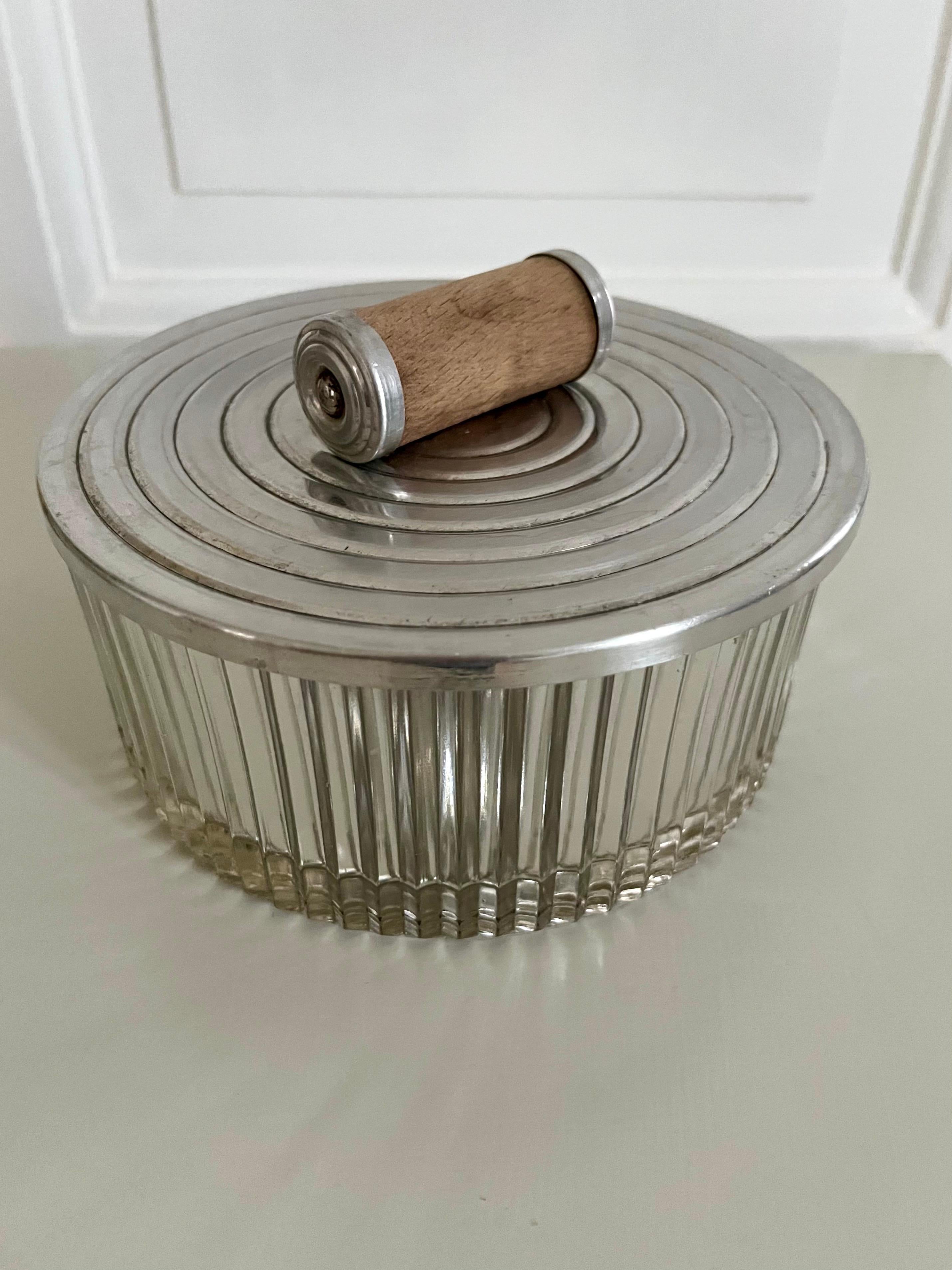 Joyero de cristal Art Decó danés / Tarro decorativo con tapa, años 30

Elegante joyero danés Art Decó o tarro decorativo con tapa de los años 30. Presenta un cuerpo de cristal estriado con una tapa metálica estriada a juego, adornada con un asa de