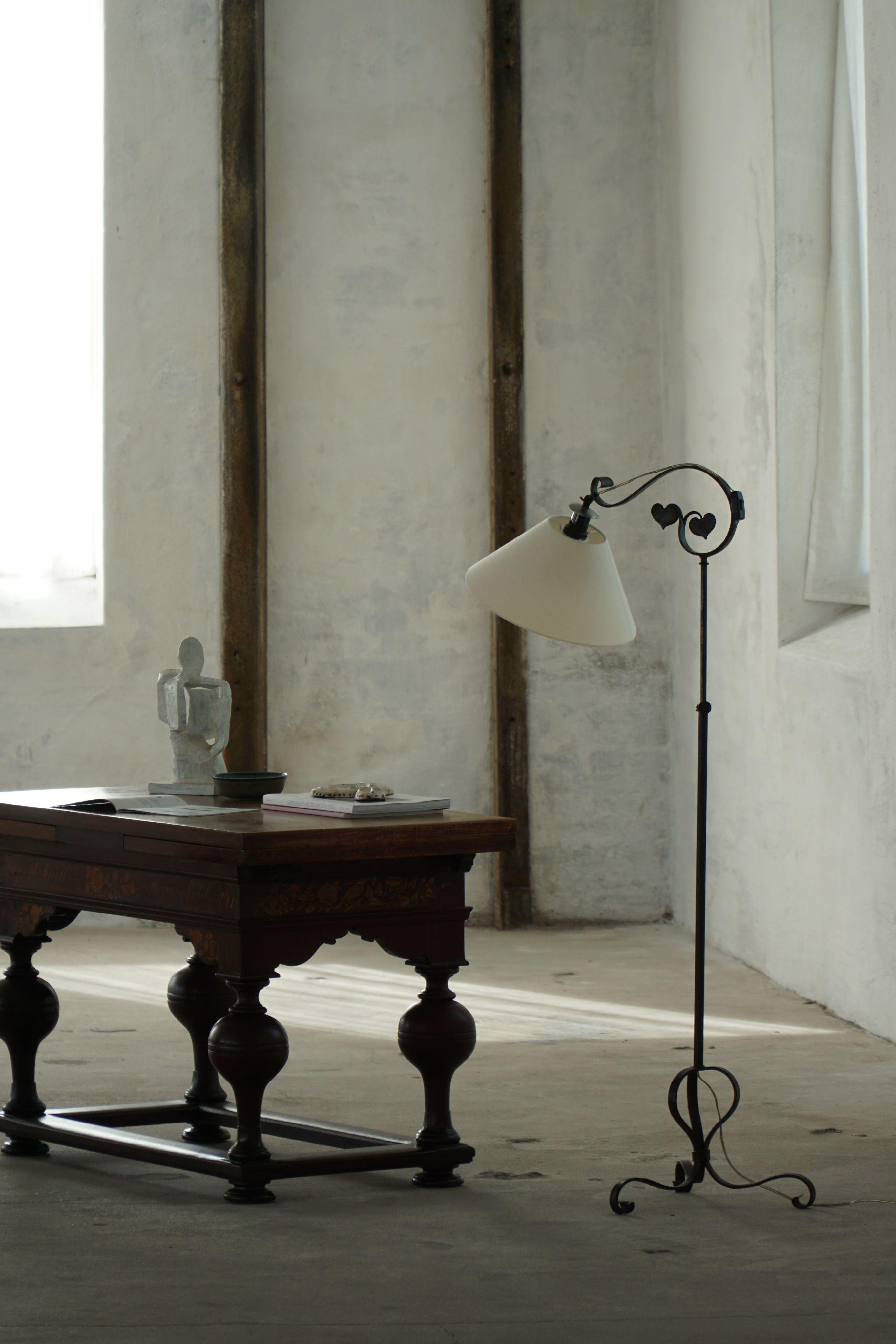 Exemple frappant de l'artisanat scandinave Art déco, ce lampadaire danois des années 1930 est forgé à la main en fer forgé avec d'élégantes volutes et des détails raffinés. La tige en fer élancée s'élève sur une gracieuse base tripode aux pieds