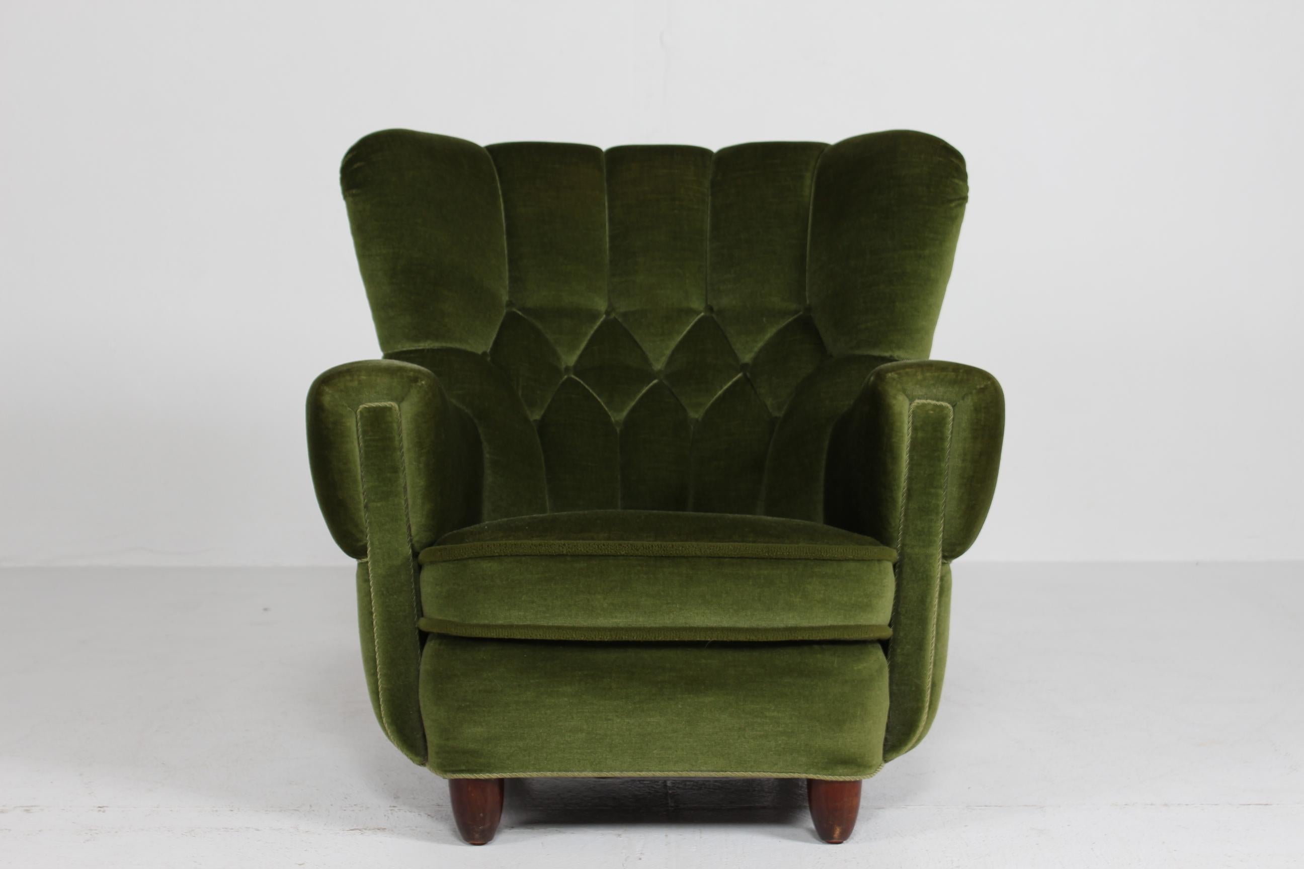 Danish Art Deco high back lounge chair fully upholstered with dark green velvet. Legs of dark stained oak, the two front legs are round and pointed.

Handmade in the 1940s by Danish carpenter and tightly upholstered by skilled furniture