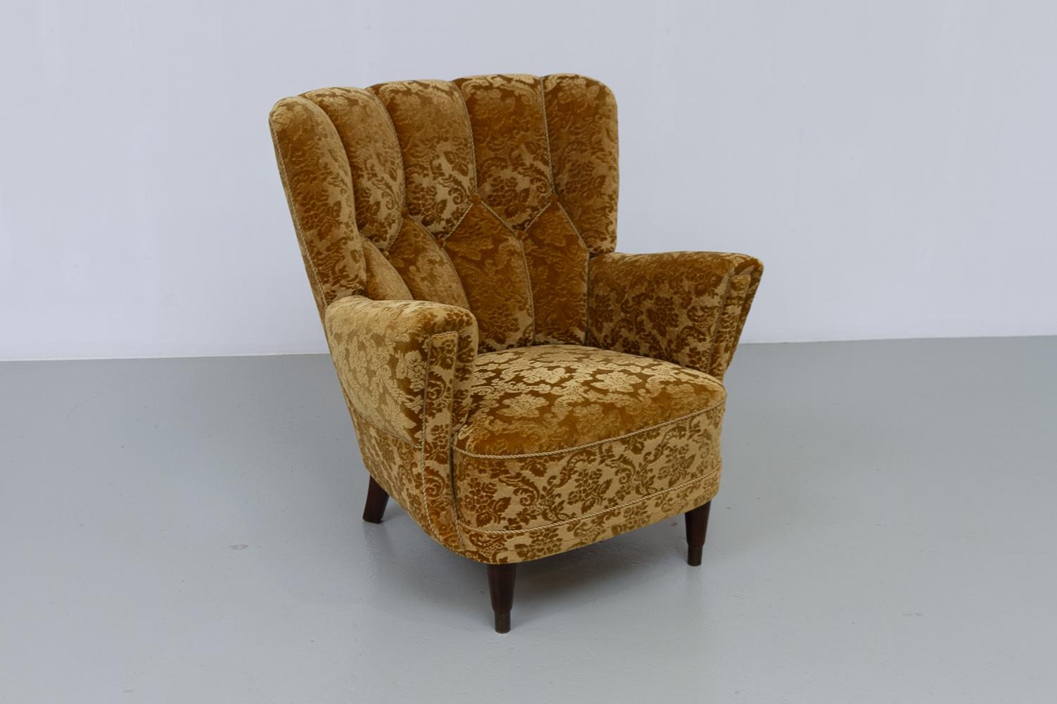 Chaise longue danoise Art déco en velours jaune doré, années 1940

Magnifique, douillet et confortable fauteuil de salon à oreilles tapissé de velours jaune d'or avec des motifs floraux en relief. Pieds en hêtre teinté foncé, pieds avant avec pieds