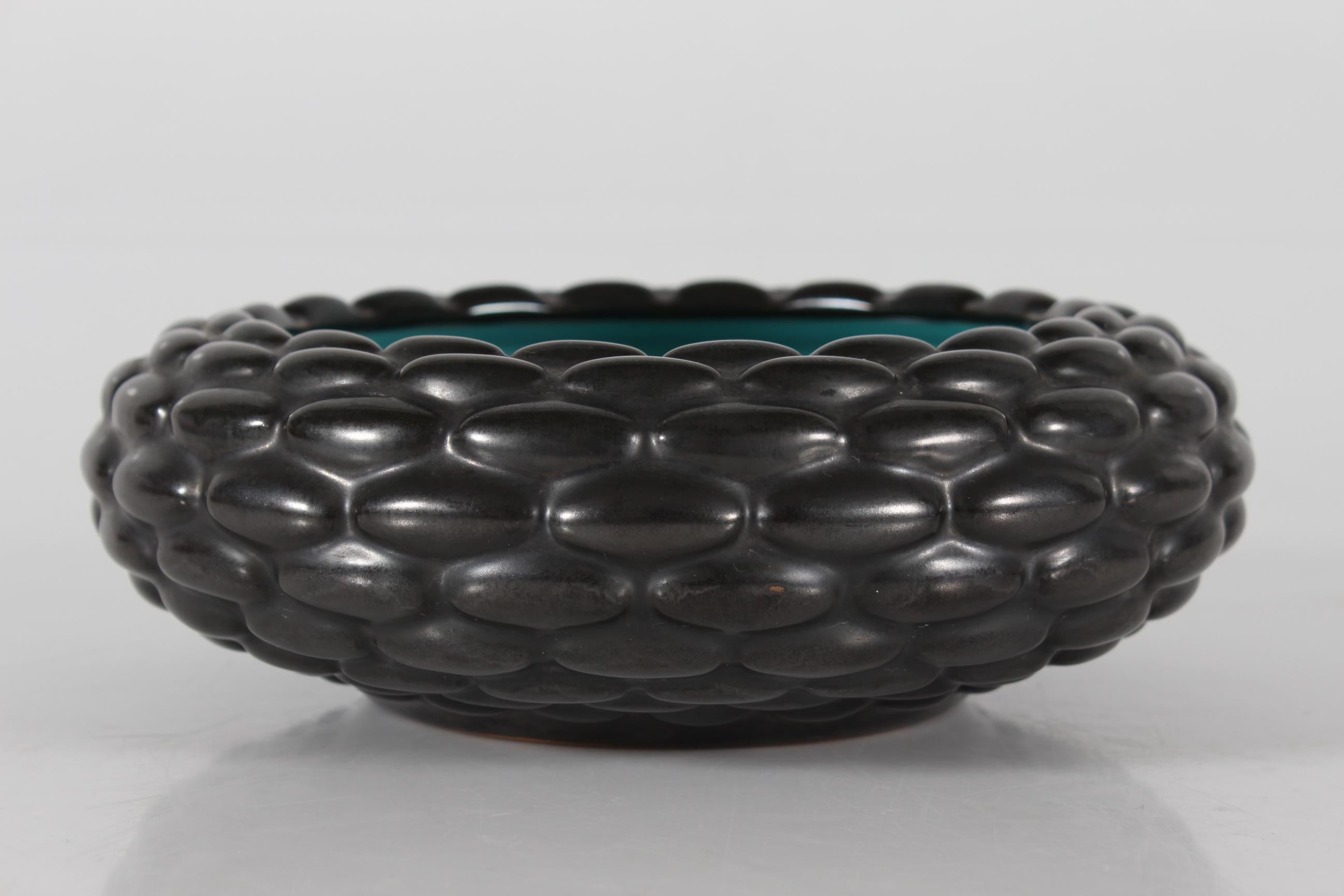 Danish Art Deco Axel Salto style bowl from the ceramic workshop Michael Andersen & Søn (MA&S). Designed and made ca. 1930s to 1950s.

The outside with its budding design covered with satin black glaze is contrasted by a smooth inside with glossy
