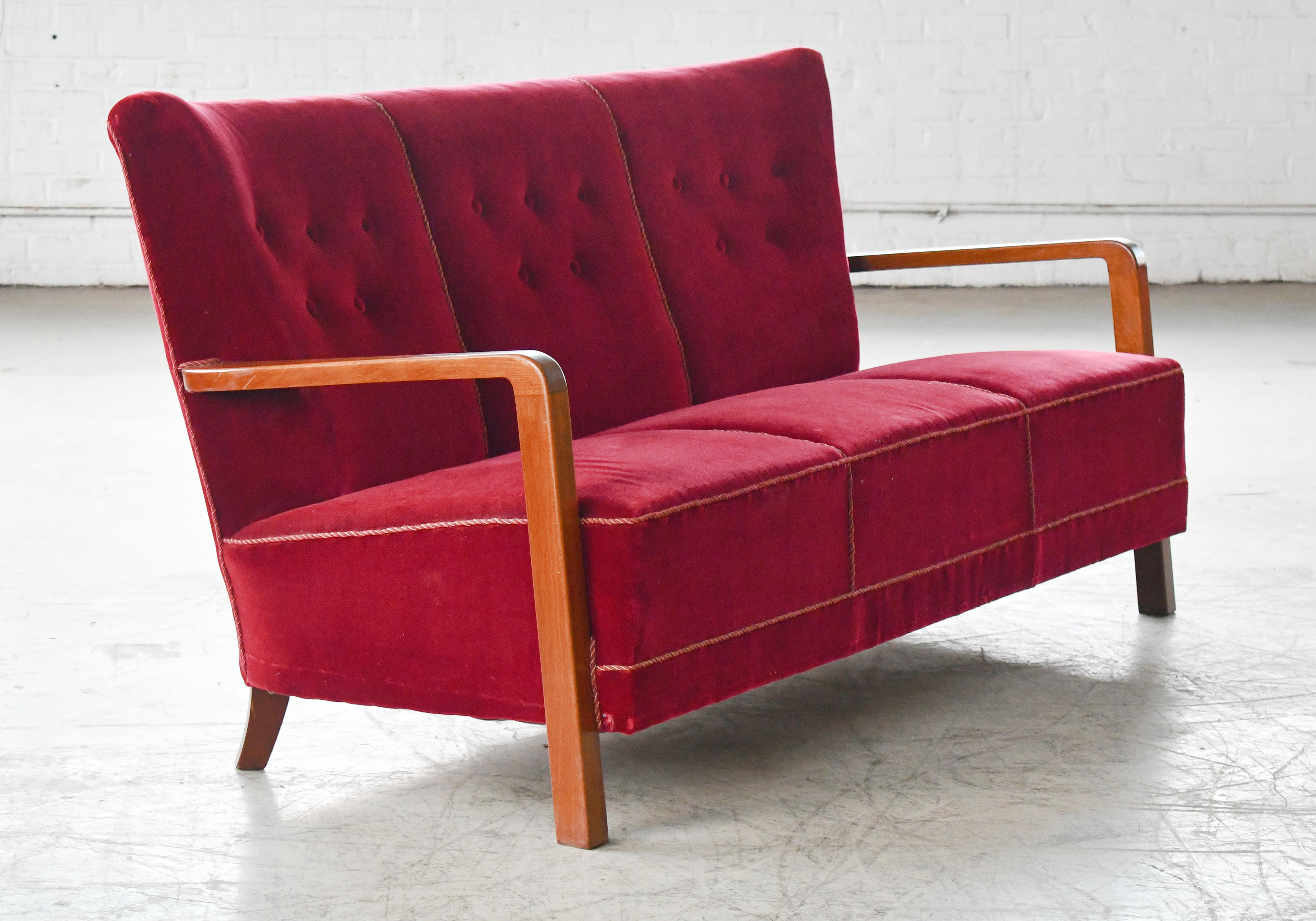 Superb Danish late Art Deco early midcentury sofa from the late 1930's or early 1940s with spring cushions and beautiful open armrests and legs carved in solid Cuban mahogany with great grain and patina. We just love the simple yet very refined