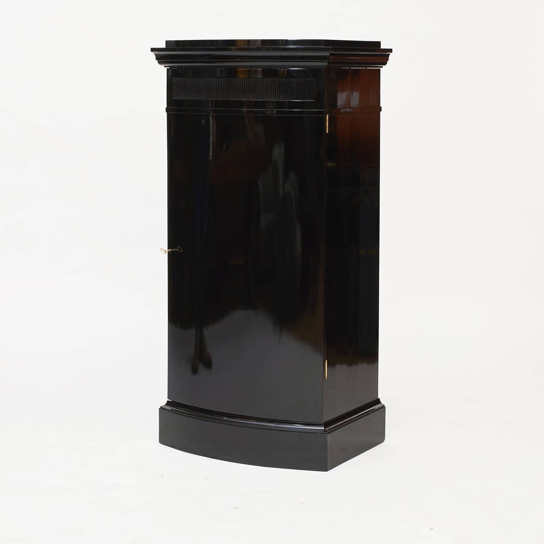 Danish art deco pedestal cabinet in ebonized mahogany.
Offers a convex front with a single door that opens to reveal five shelves.

Made in high quality by carpenter master Otto Meyer, Copenhagen 1916.
Inside of door with handwritten