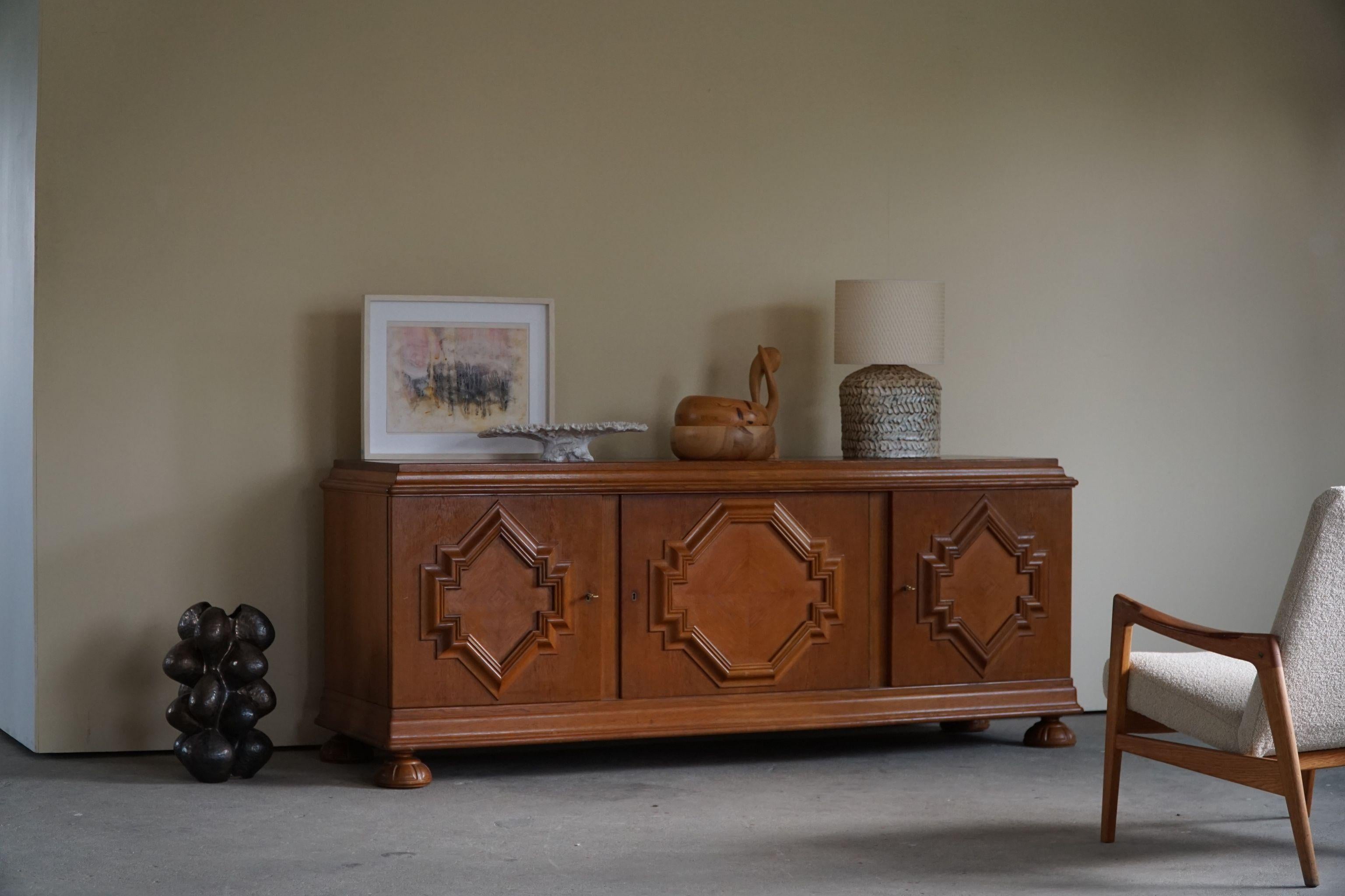 Danish Art Deco sideboard in solid oak, made in the early 20th century. Chunky legs and a sculptural front, this sideboard can easily be paired with modern interior. Such as other Danish designers, like Wegner or a Swan from Arne Jacobsen.