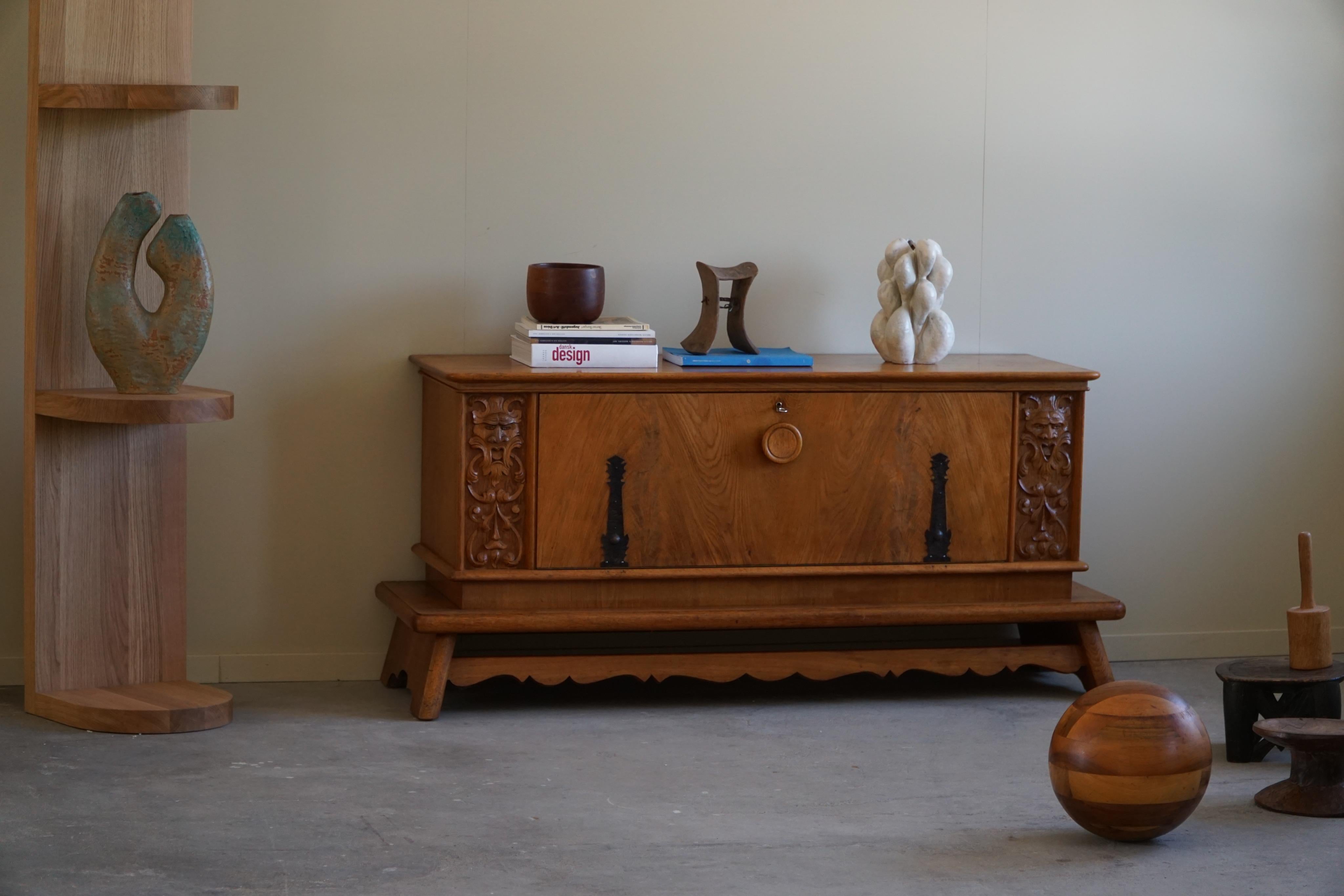 Danish Art Deco sideboard in solid oak, made in the early 20th century. With its chunky legs and a sculptural front, this sideboard can easily be paired with a modern interior. Such as other Danish designers, like Wegner or a Swan from Arne