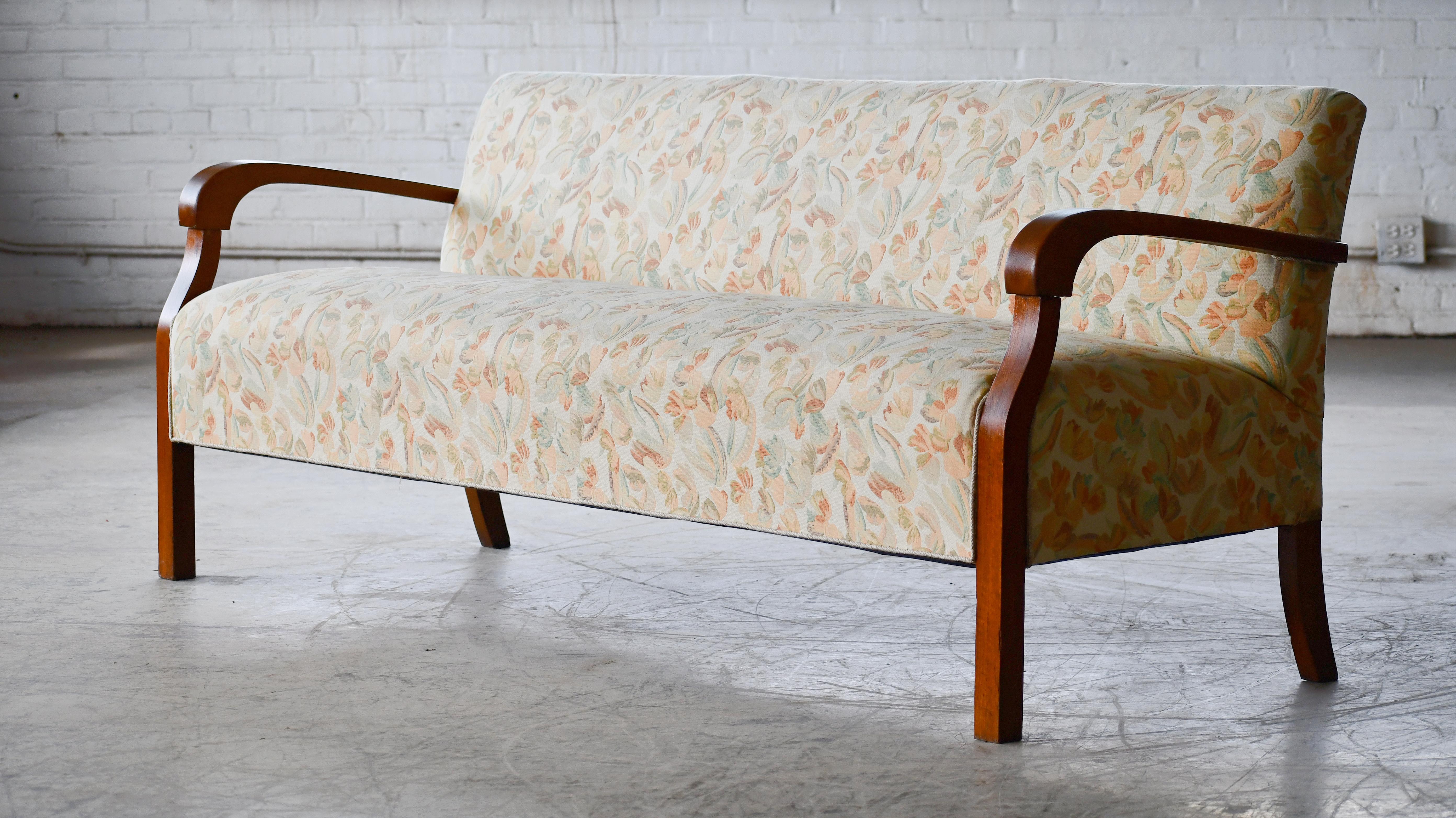 Superb Danish late Art Deco early midcentury sofa from the late 1930's or early 1940s with spring cushions and beautiful open armrests and legs carved in solid stained beech with great grain and patina. We just love the simple yet very refined