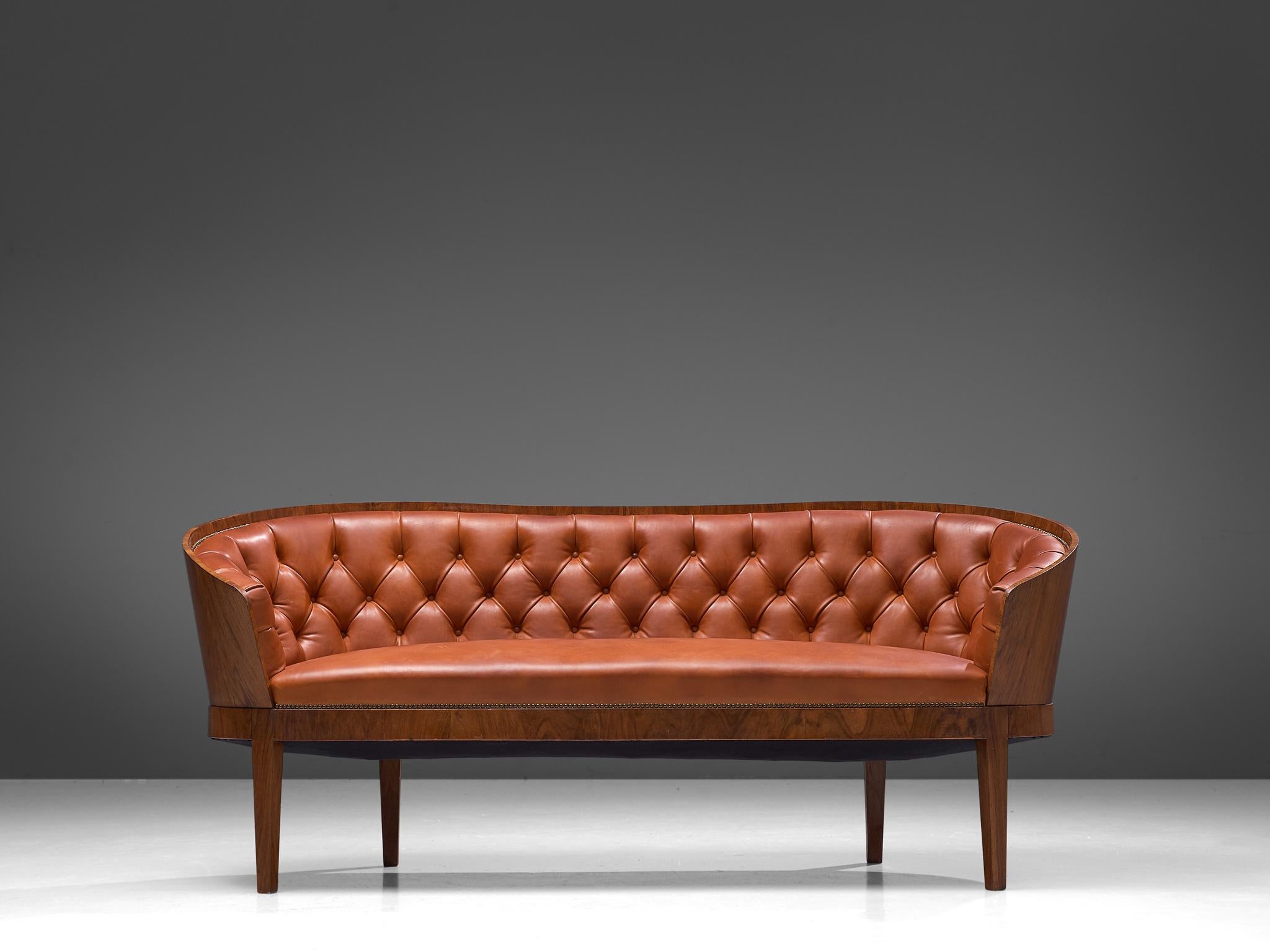 Sofa, walnut and leather, Denmark, 1920s

A beautiful Danish sofa executed in a walnut frame and upholstered in warm cognac colored leather. The voluptuous upholstered backrest is deep-buttoned tufted and finished with nails. The frame of the back