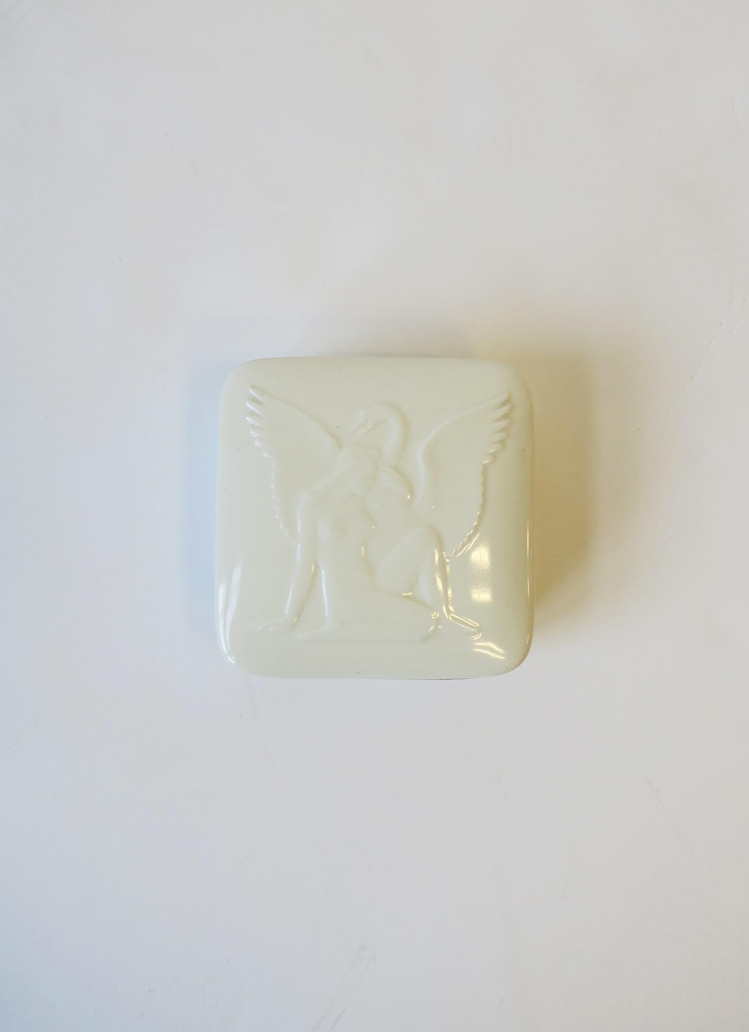 A beautiful white porcelain box with female figure and swan bird design by Royal Copenhagen, Art Deco period, Denmark, circa early-20th century. A great piece for jewelry or other small items on a desk, vanity, nightstand table, etc., or as a