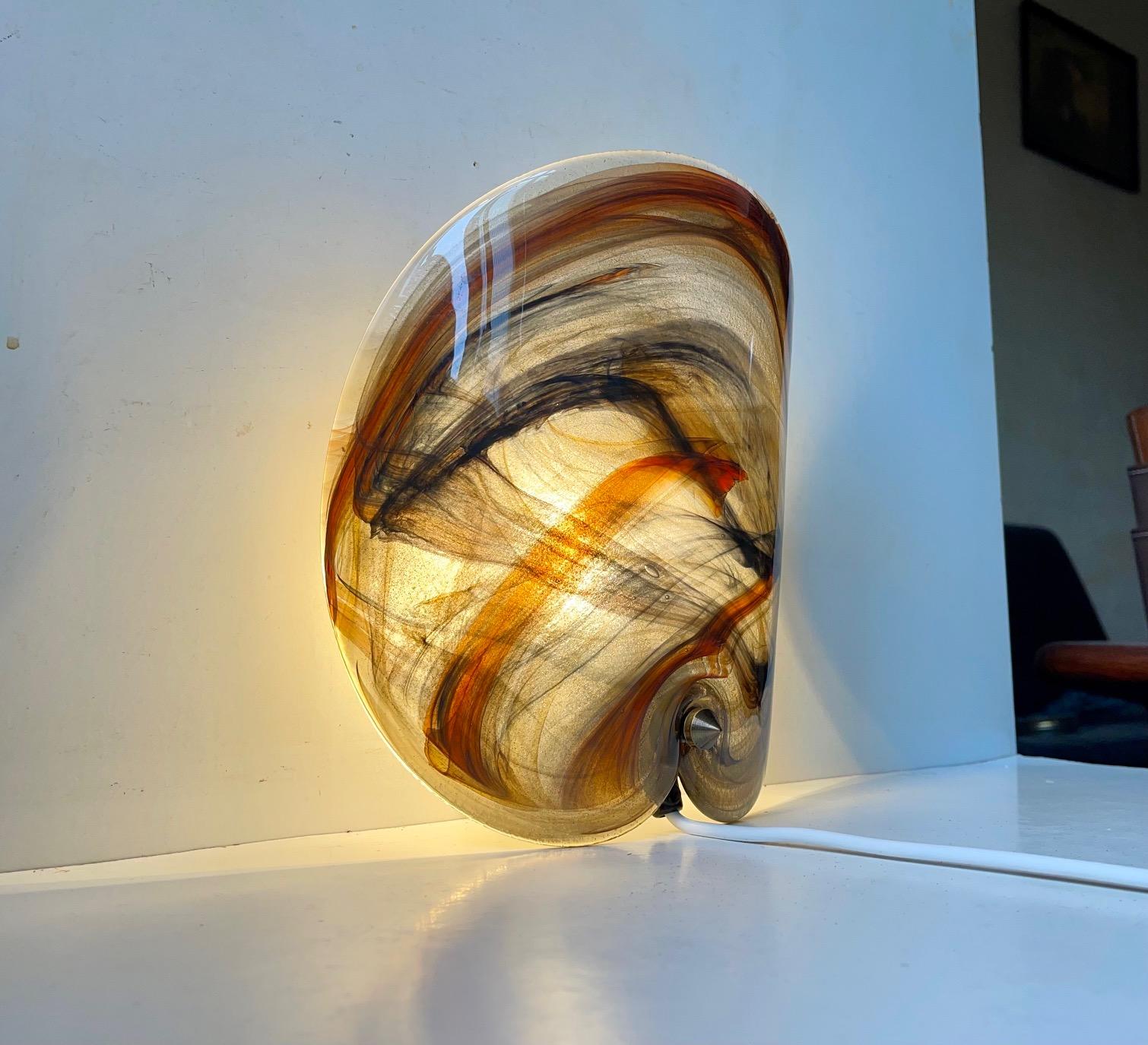 Bend circular wall sconce made from thick hand blown glass with incapsulated glass threads in orange, black, grey, brown etc. It was designed by Per Lütken and manufactured Holmegaard in Denmark during the late 1970s. Measurements: 25 x 22 x 10 cm.