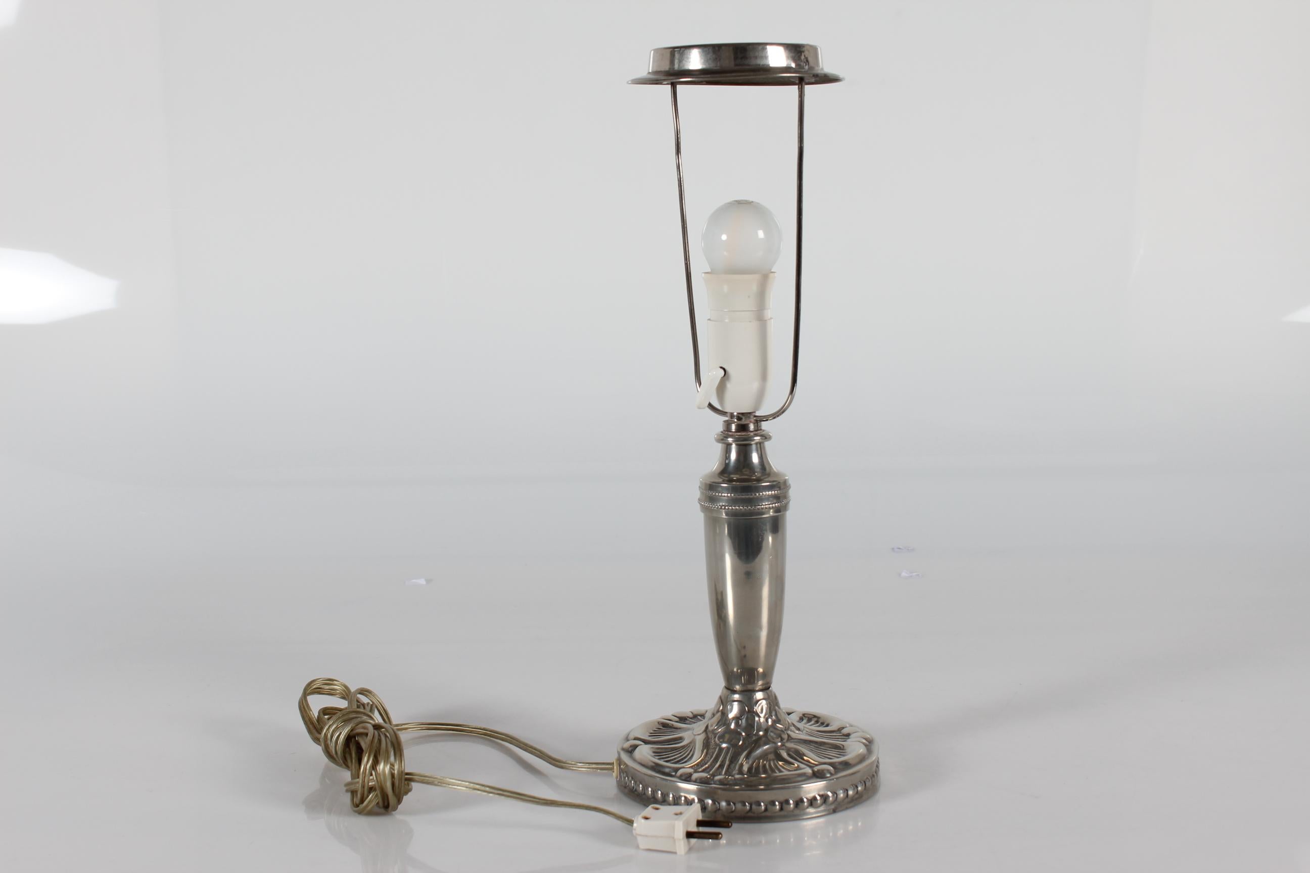 Danish Art Nouveau table lamp made of pewter with floral pattern.

The lamp is manufactured in Denmark in the period 1920s-1930s 

Included is a new lamp shade designed in Denmark. It is made of woven fabric with some texture and it is natural