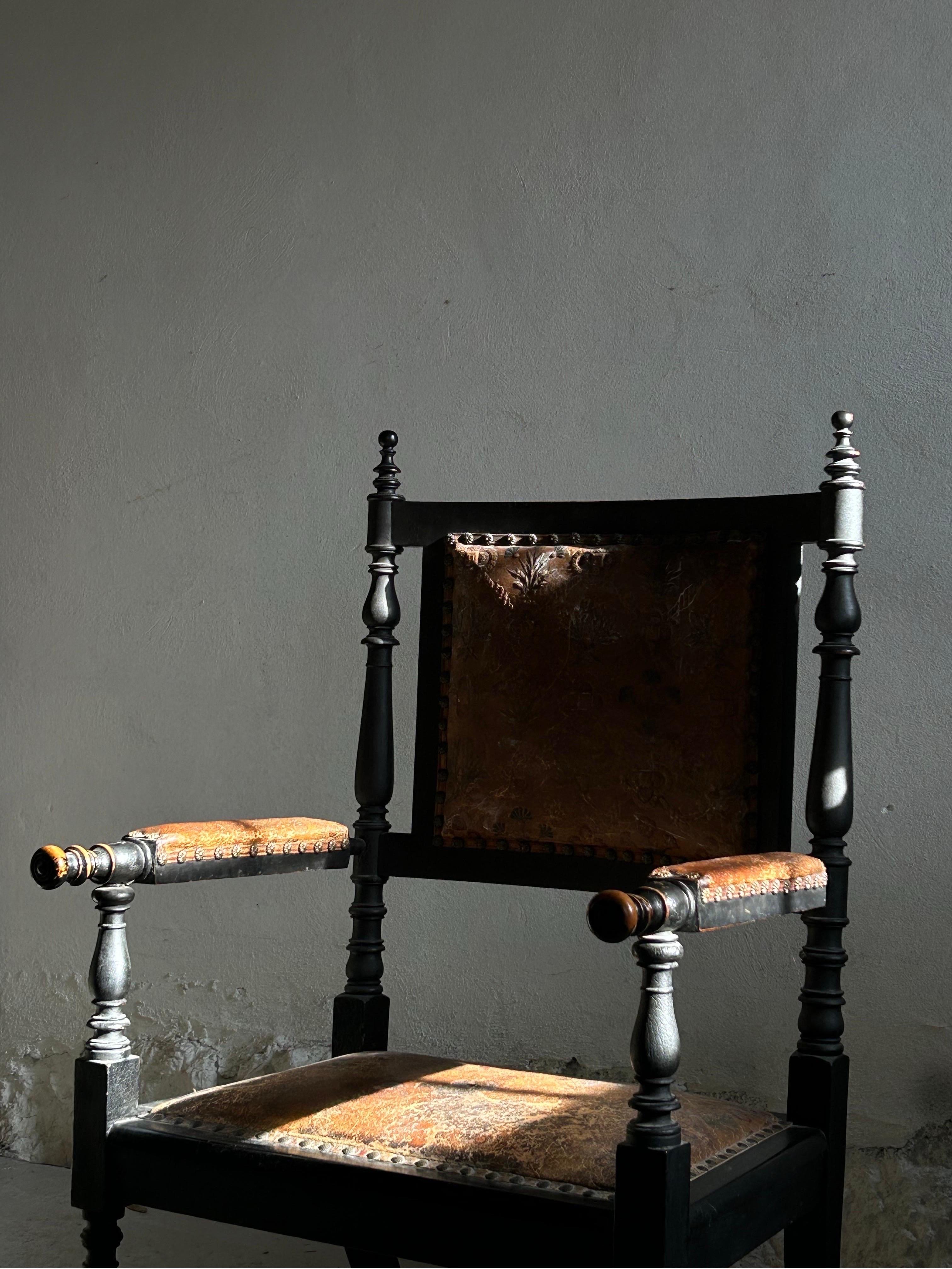 This remarkable Danish artist chair, dating from the 1890s, is crafted from ebonized wood and retains its original embossed leather upholstery, showcasing a perfect blend of craftsmanship and artistic detail. The chair’s refined design, with its