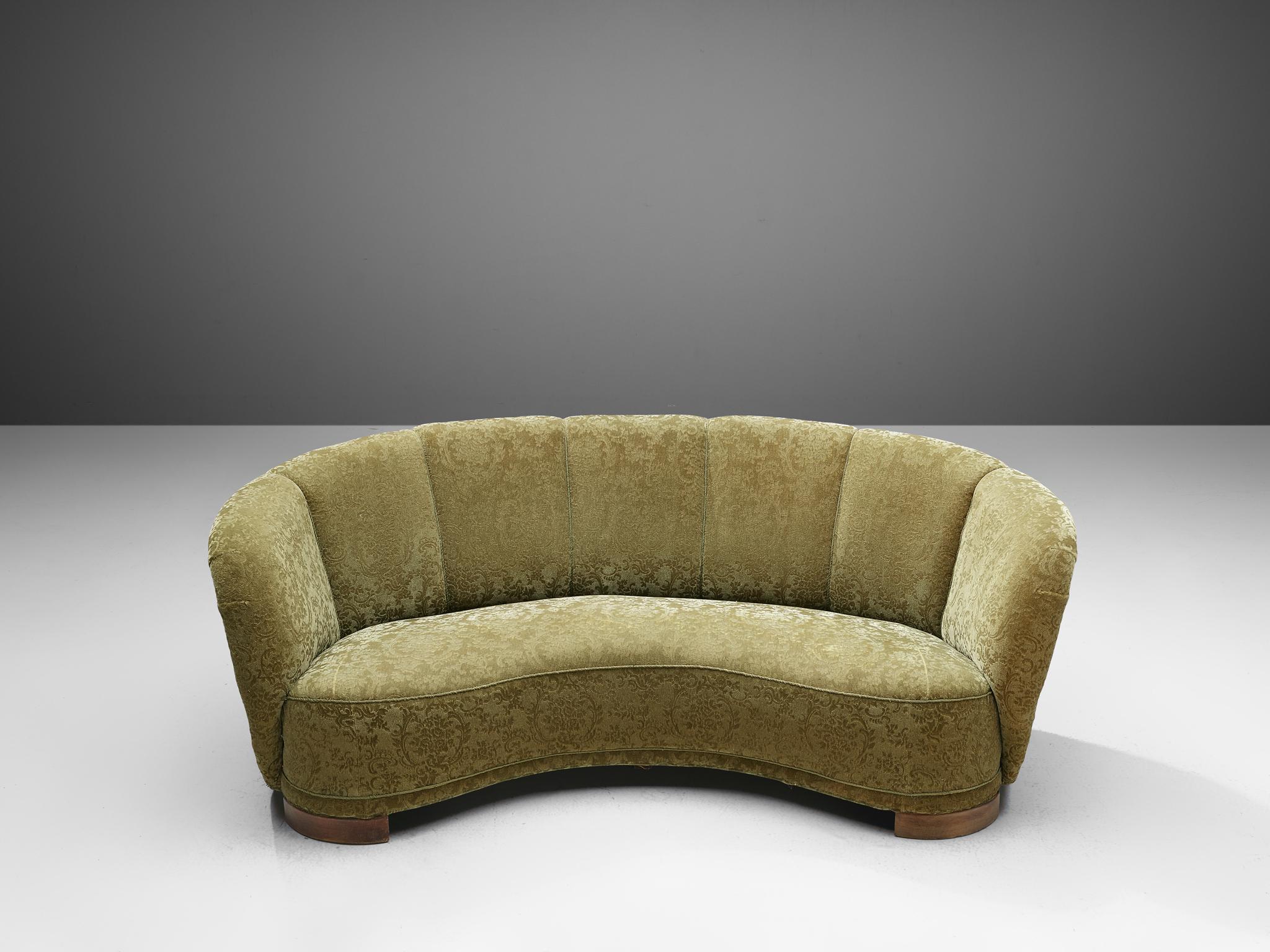 Banana sofa, textured floral upholstery and oak, Denmark, 1940s.

This voluptuous sofa is executed with wooden legs and a moss green classic floral velvet. The sofa has a high lined and curved back, while the backrest is horizontal straight and