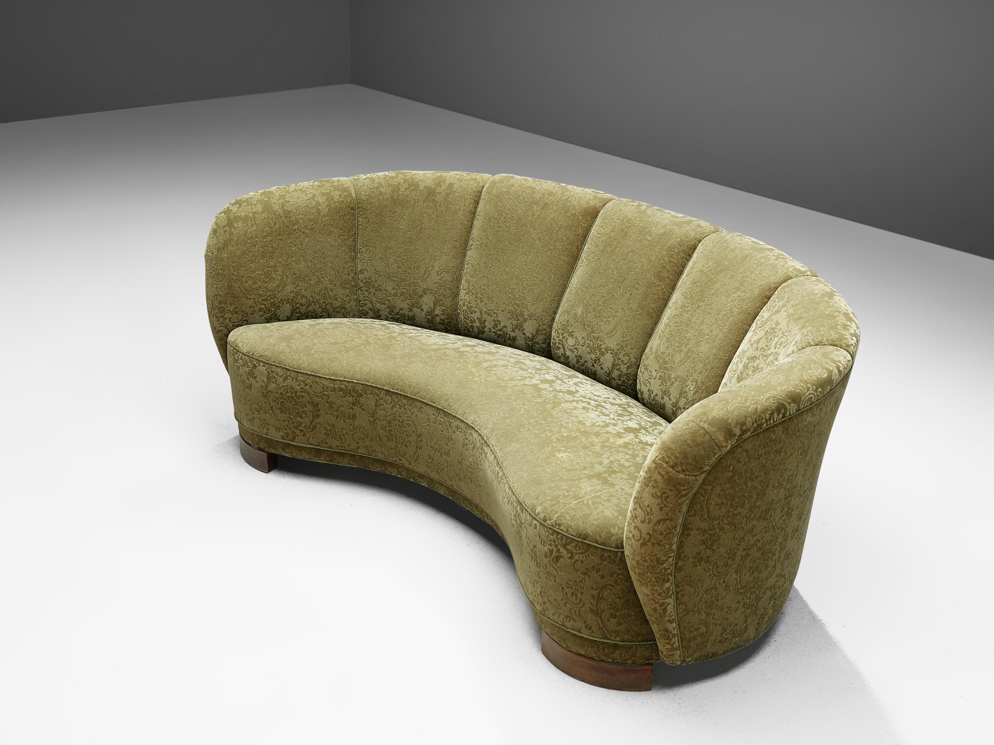 Banana sofa, textured floral upholstery and oak, Denmark, 1940s.

This voluptuous sofa is executed with wooden legs and a moss green classic floral velvet. The sofa has a high lined and curved back, while the backrest is horizontal straight and