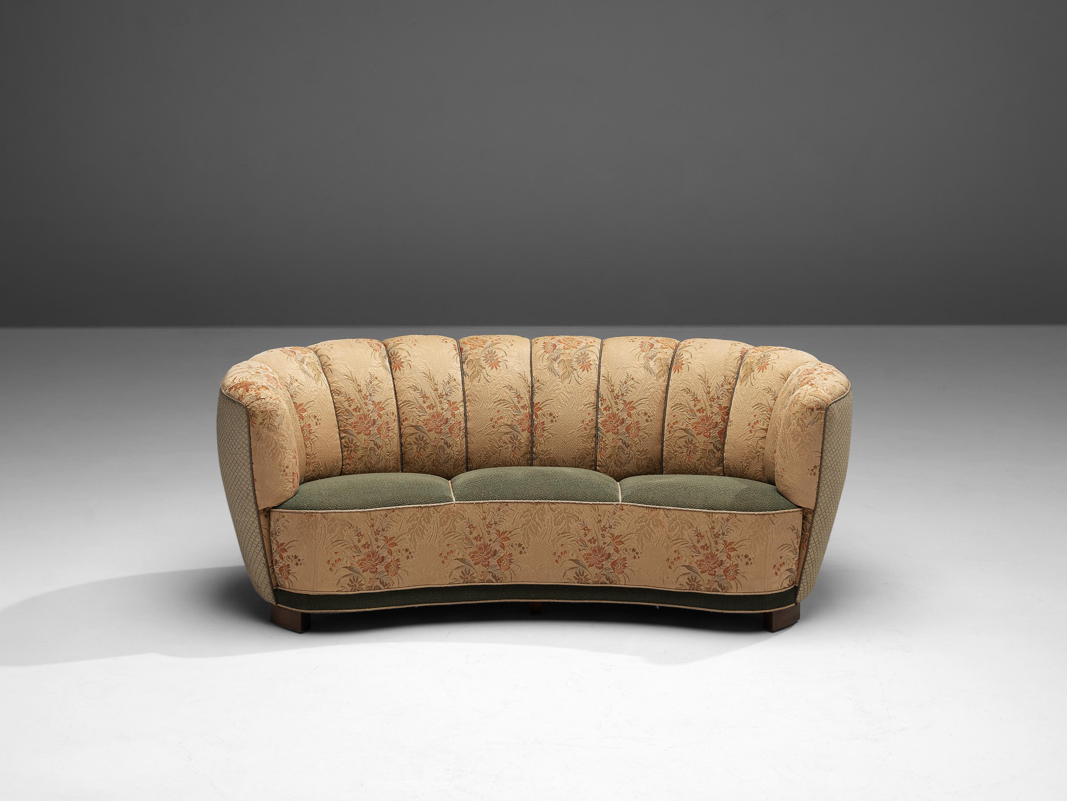 Bananensofa, geblümte Polsterung, Holz, Dänemark, 1940er Jahre.

Dieses üppige Sofa ist mit einem geblümten Stoff und Holzbeinen ausgestattet. Das Sofa hat eine hochgezogene und geschwungene Rückenlehne. Die Rückenlehne ist geschwungen und geht in