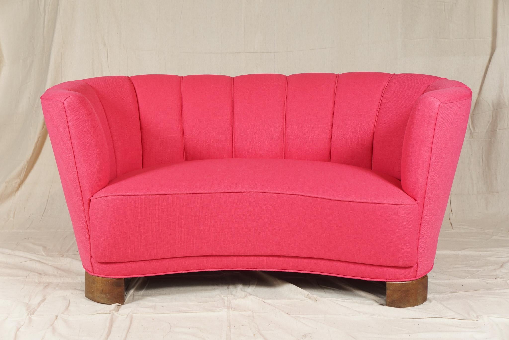 Pretty in pink. Danish modern curved sofa known as a 'banana' sofa, with channeled back and beechwood legs, from the 1950s, newly recovered. Slagelse Møbelvaerk Furniture.