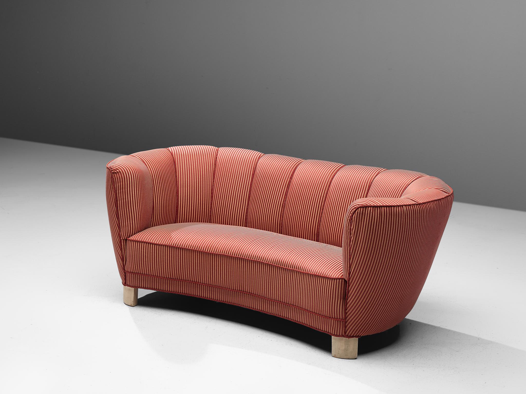 Banana sofa, fabric, wood, Denmark, 1940s.

This voluptuous sofa is executed in a striped red fabric with wooden legs. The sofa has a high lined and curved back, while the backrest is horizontal straight and flows over into the bulky, rounded