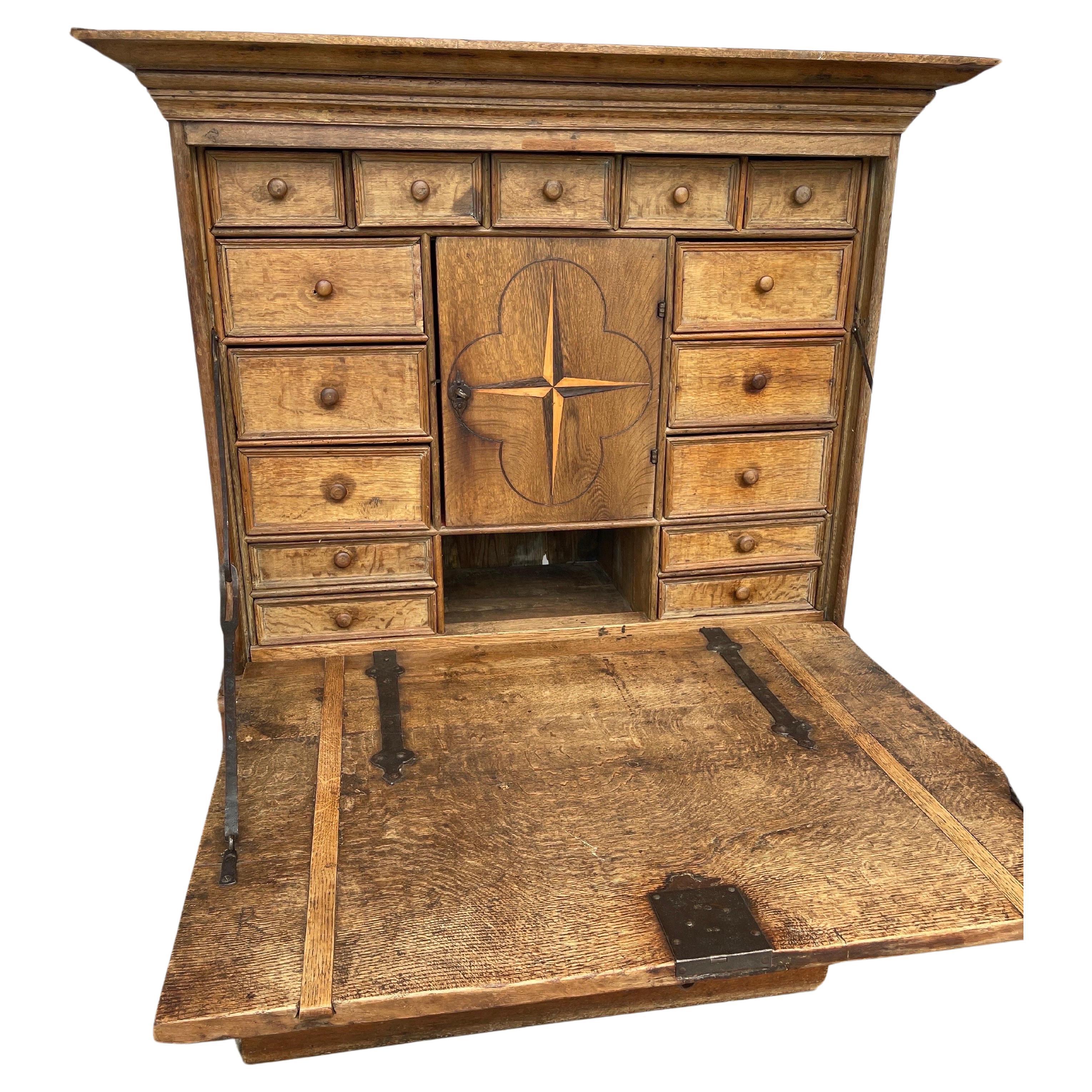Baroque cabinet with pull down writing desk table top and interior drawers.
Both the exterior and the interior cabinet panels has the a four-pointed star  decor, representing the compass that keeps us on the right road, the path of peace. 