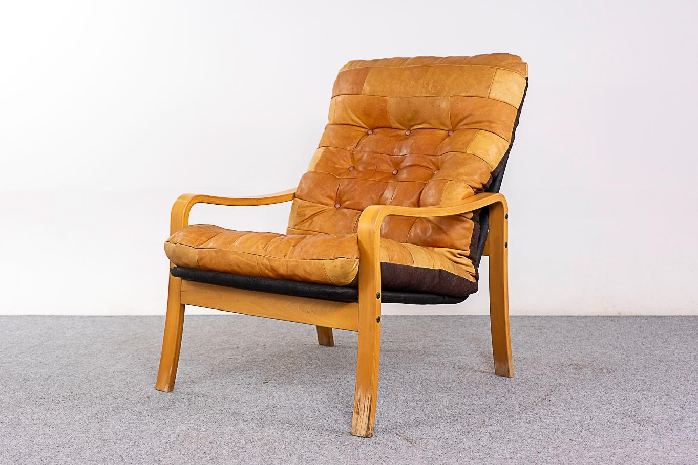 Beech & leather lounge chair, circa 1970's. Curvaceous frame with original patchwork leather upholstery, some wear & tear.

Unrestored item with option to purchase in restored condition for an additional $200 USD. Restoration includes: repairs,