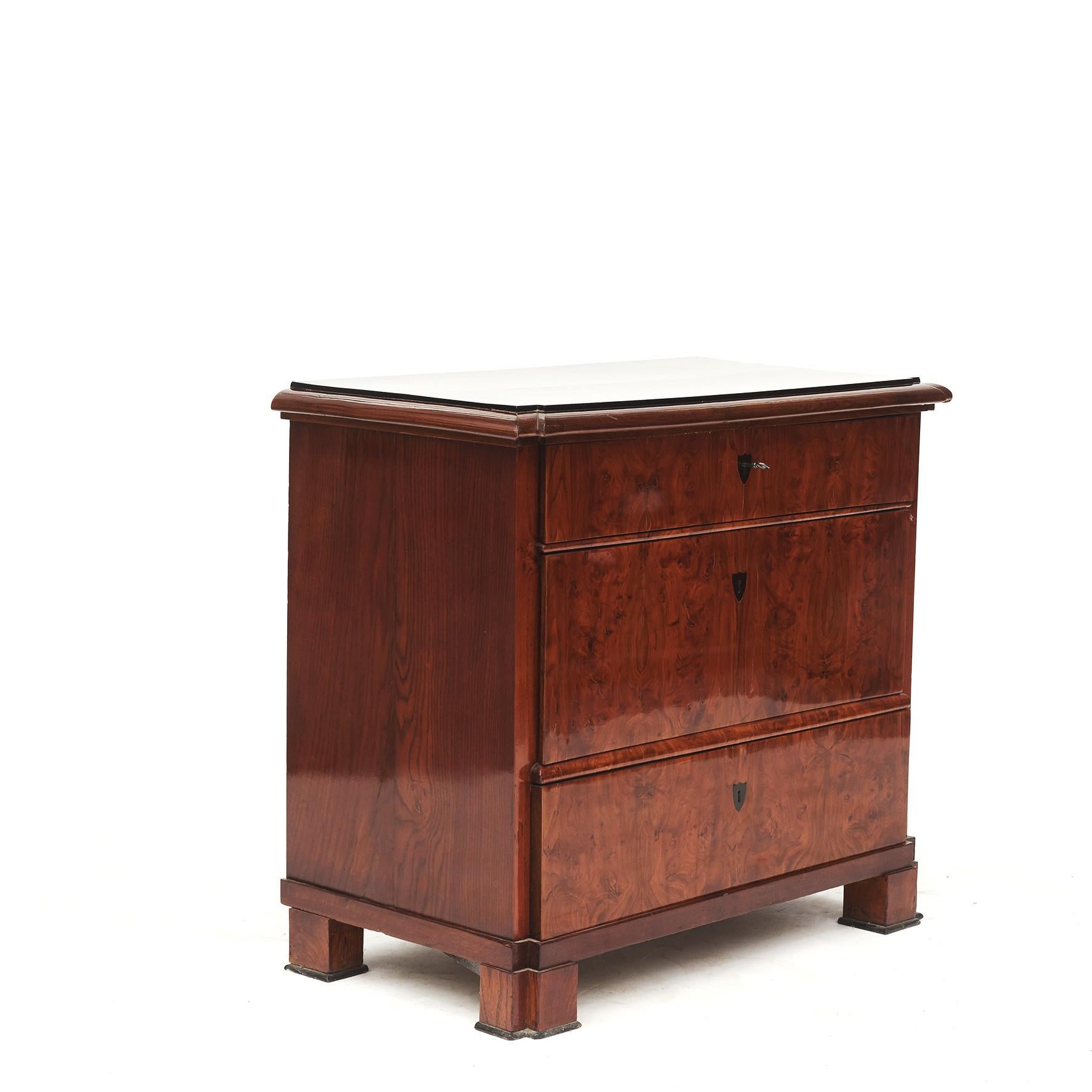 Danish biedermeier (also called late empire) chest of drawers.
Elm wood, front with mirrored elm veneer, sides in solid elm and ebonized top.
Denmark 1820-1830.