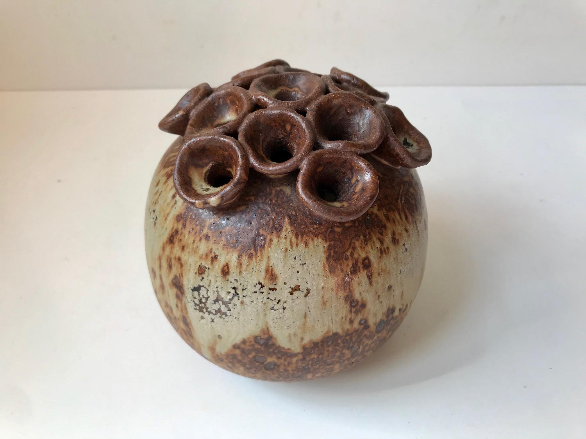 This Danish stoneware vase comes in a biomorphic shape with applied tentacles and earthy glazes. It was designed by ceramist Dorthe Visby at her workshop in Tjaereborg, Denmark during the 1990s. A hole is located just below the tentacles which