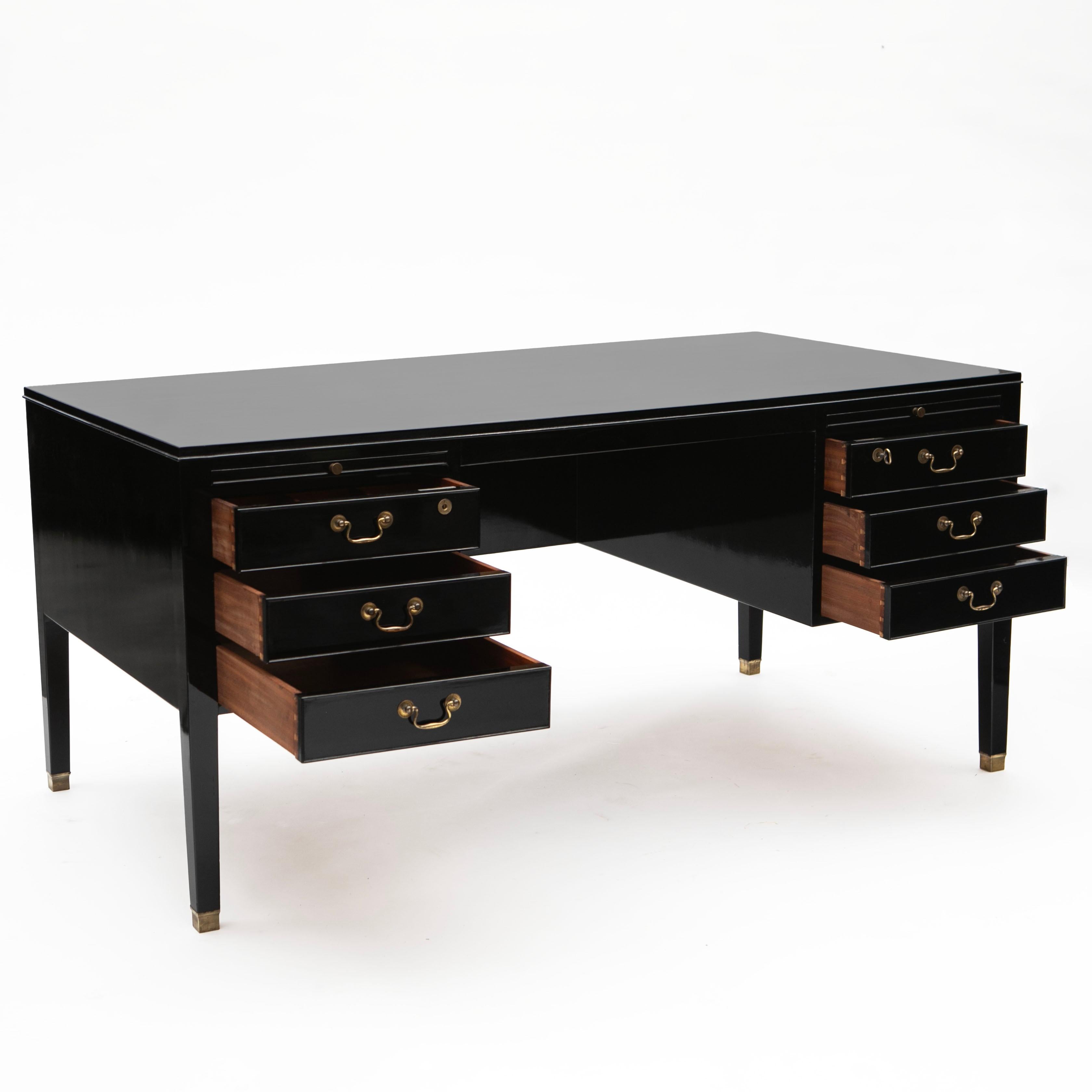 Ole Wanscher, Danish 1903-1985.

Mid-century desk in black polished mahogany by Danish cabinetmaker and designer Ole Wanscher.
Six drawers (2x3) with original brass handles and locks above pull-out trays. Resting on elegant tapered legs ending in