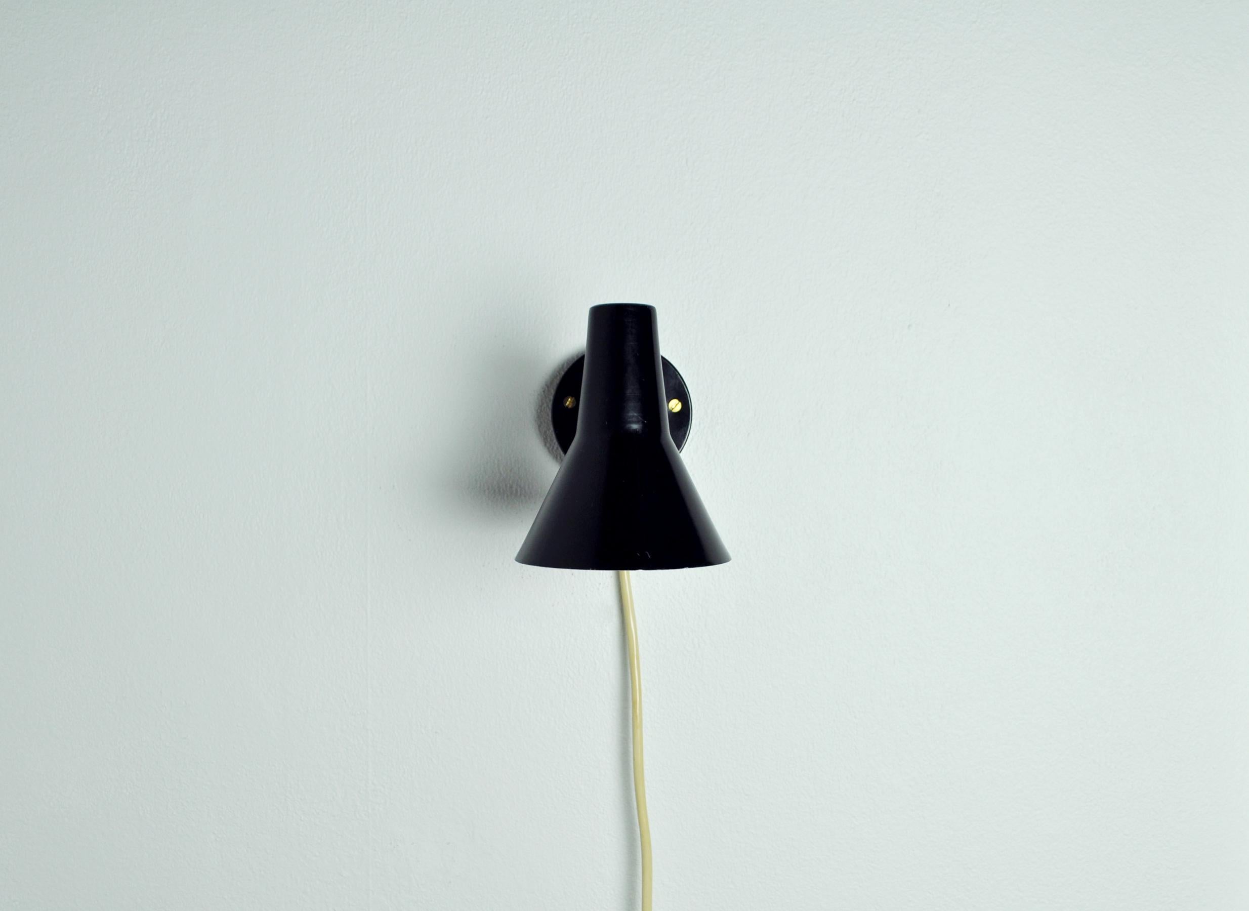 Scandinavian Modern Danish wall lamp with adjustable brass arm.
Black lacquered metal. Inner shade white.

Dimensions: 
Shade diameter 10 cm
Height 12 cm
Depth 18.5 cm.
