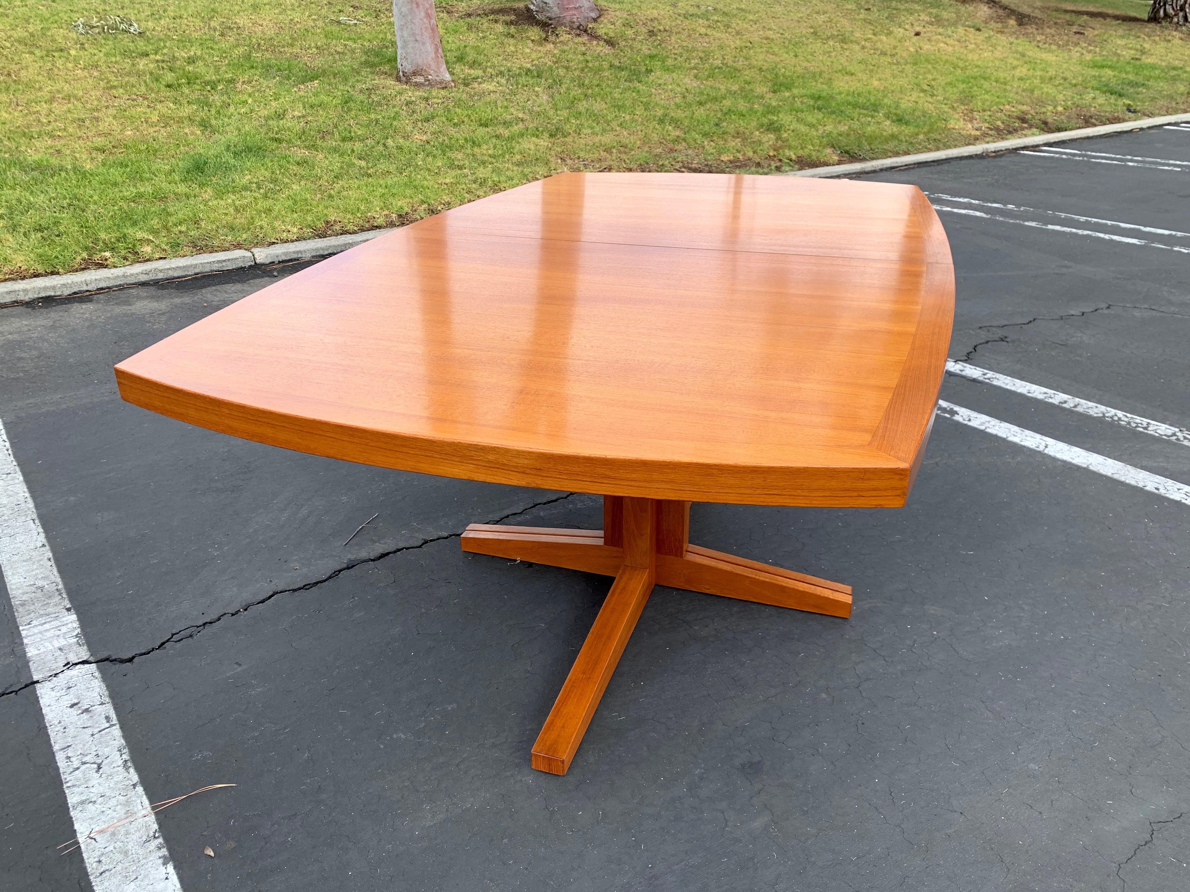 Danish modern teak dining table with boat shaped curved top also two leaves. Each leaf is 19.75