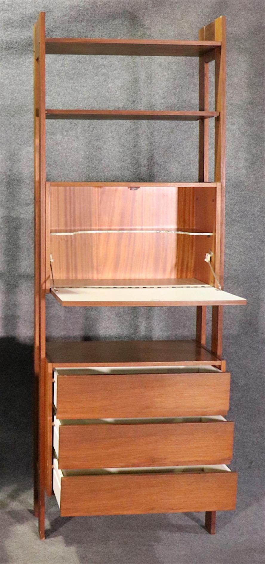 This mid-century modern standing bookcase features adjustable shelves, drawers, and drop front cabinet storage.
Please confirm location NY or NJ
