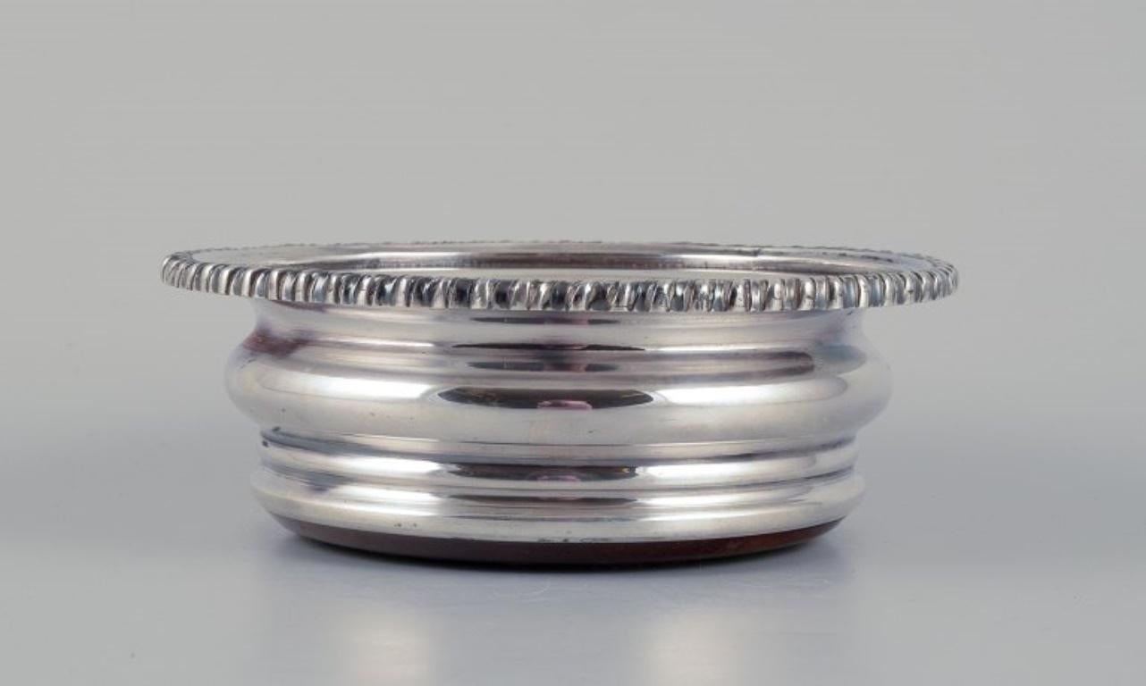 Sottobicchiere danese in argento placcato e legno. Di alta qualità e pesante.
Approssimativamente dagli anni '30.
Non segnato.
In ottime condizioni.
Dimensioni: Diametro 15,0 cm x Altezza 5,5 cm.
Si adatta a una bottiglia con un diametro di 11,5 cm.
