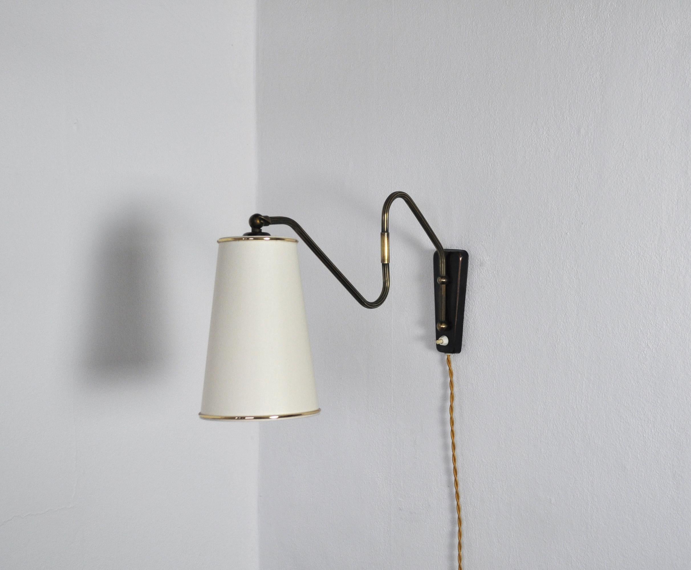 Brass wall lamp with two-piece swing arm and adjustable head.
Swivel and wall mount made in brass, mounted with a new conical shade.  

Measures incl. shade: Arm length 50 cm
Height 27 cm
Shade diameter 9/21 cm, height 21 cm

Condition: Good