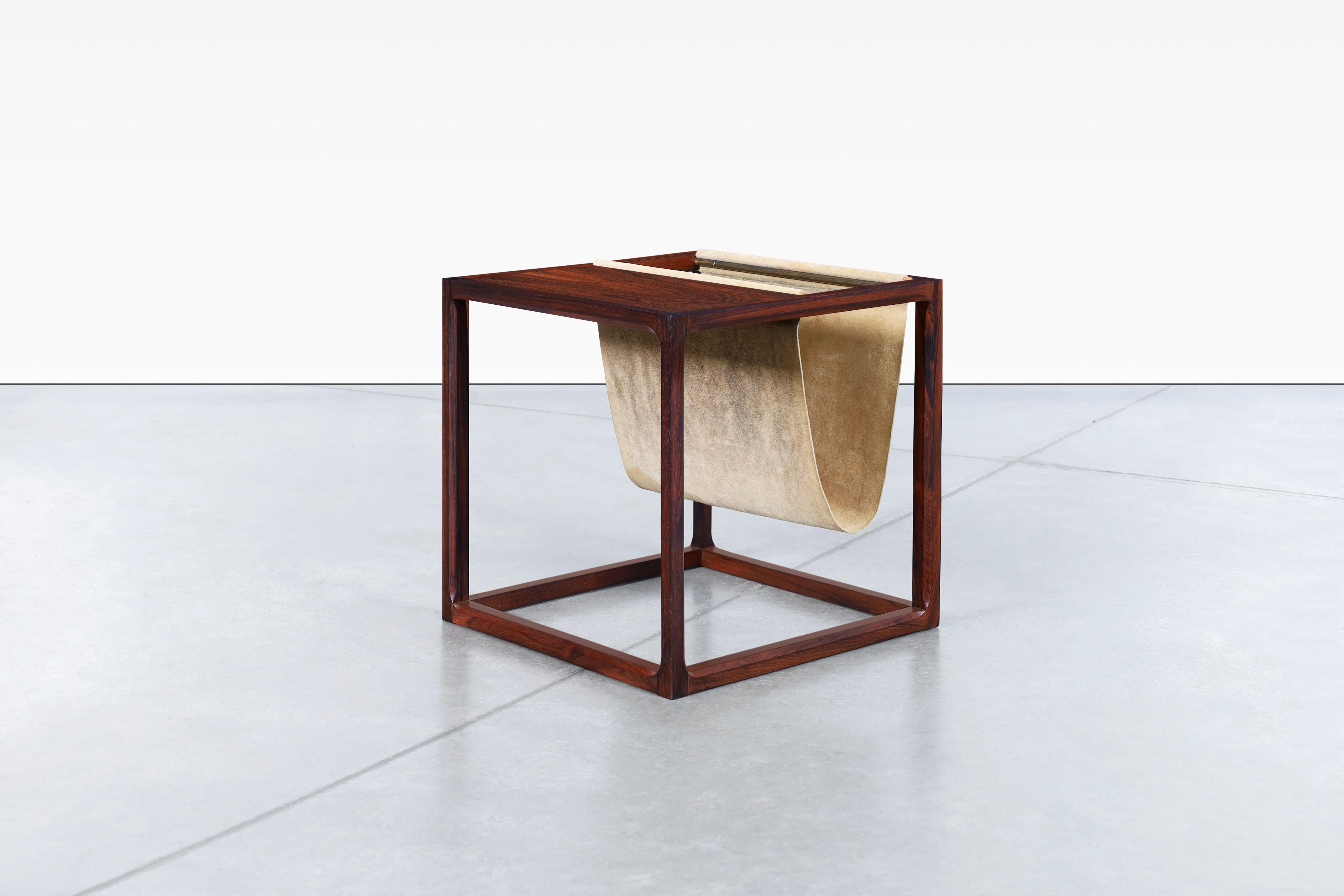 Danish Brazilian rosewood magazine rack designer by Kai Kristiansen for Aksel Kjersgaard in Denmark, circa 1960s. Add a touch of versatility to your living space with this exquisite magazine rack crafted from Brazilian rosewood. With its refined