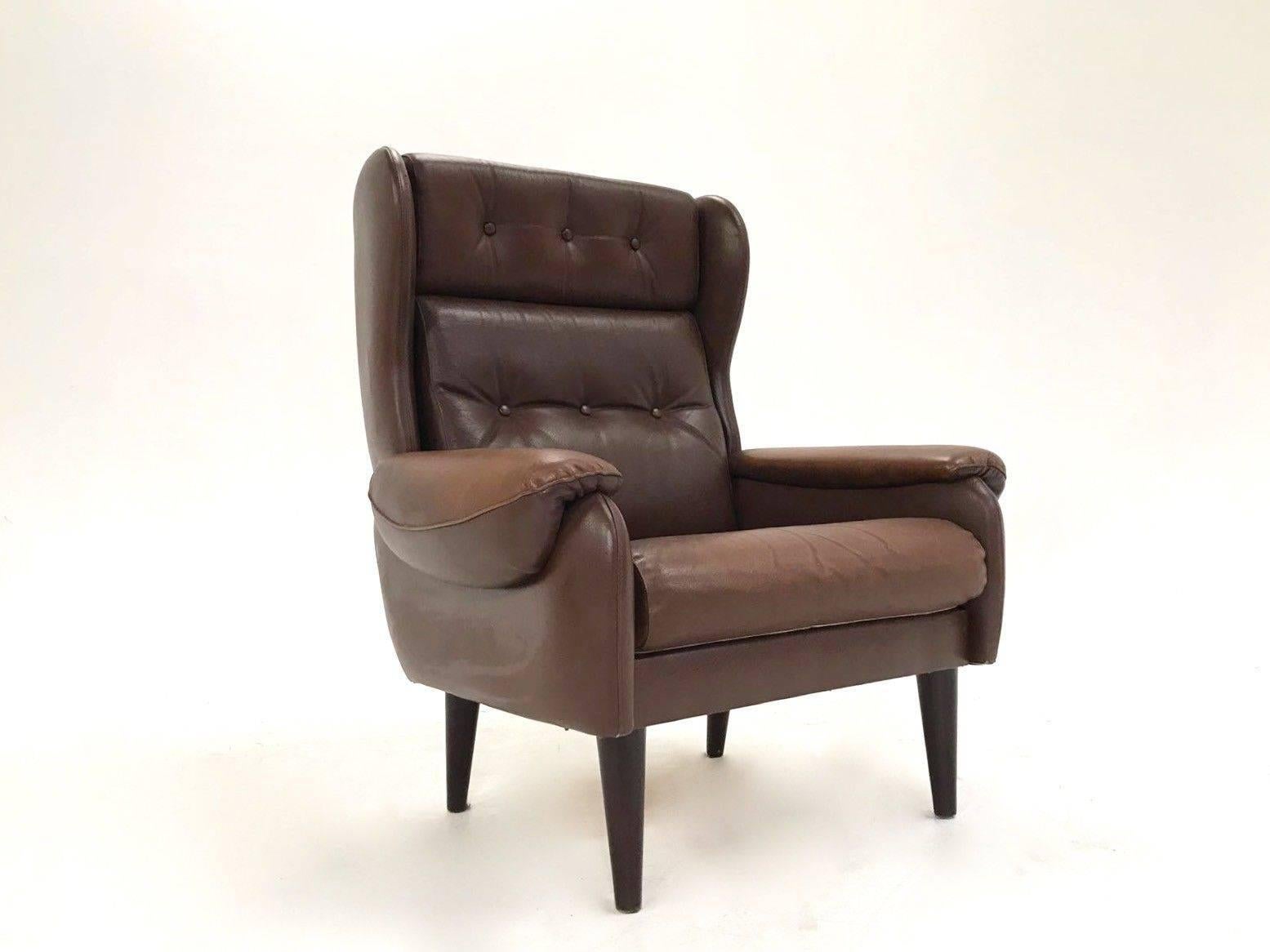 A beautiful Danish brown leather high back armchair, this would make a stylish addition to any living or work area. The chair has a high buttoned back and padded armrests for enhanced comfort. A striking piece of classic Scandinavian