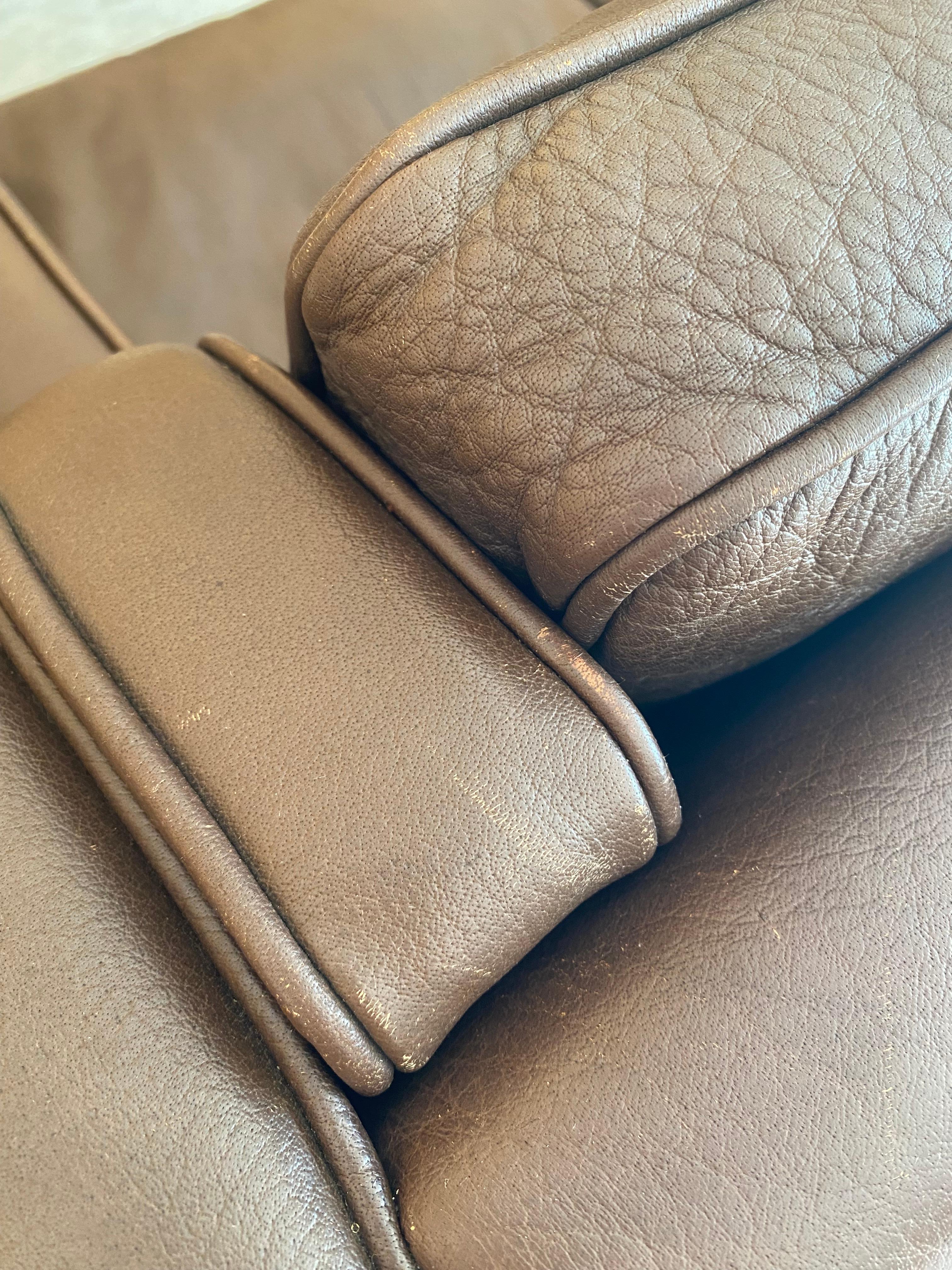 Divano a poltrona in pelle marrone di Stouby Polster Møbelfabrik in cioccolato al latte con gambe a profilo quadrato in legno biondo. Un design iconico in ottime condizioni vintage. I bordi iniziano a presentare un'usura naturale molto desiderabile,