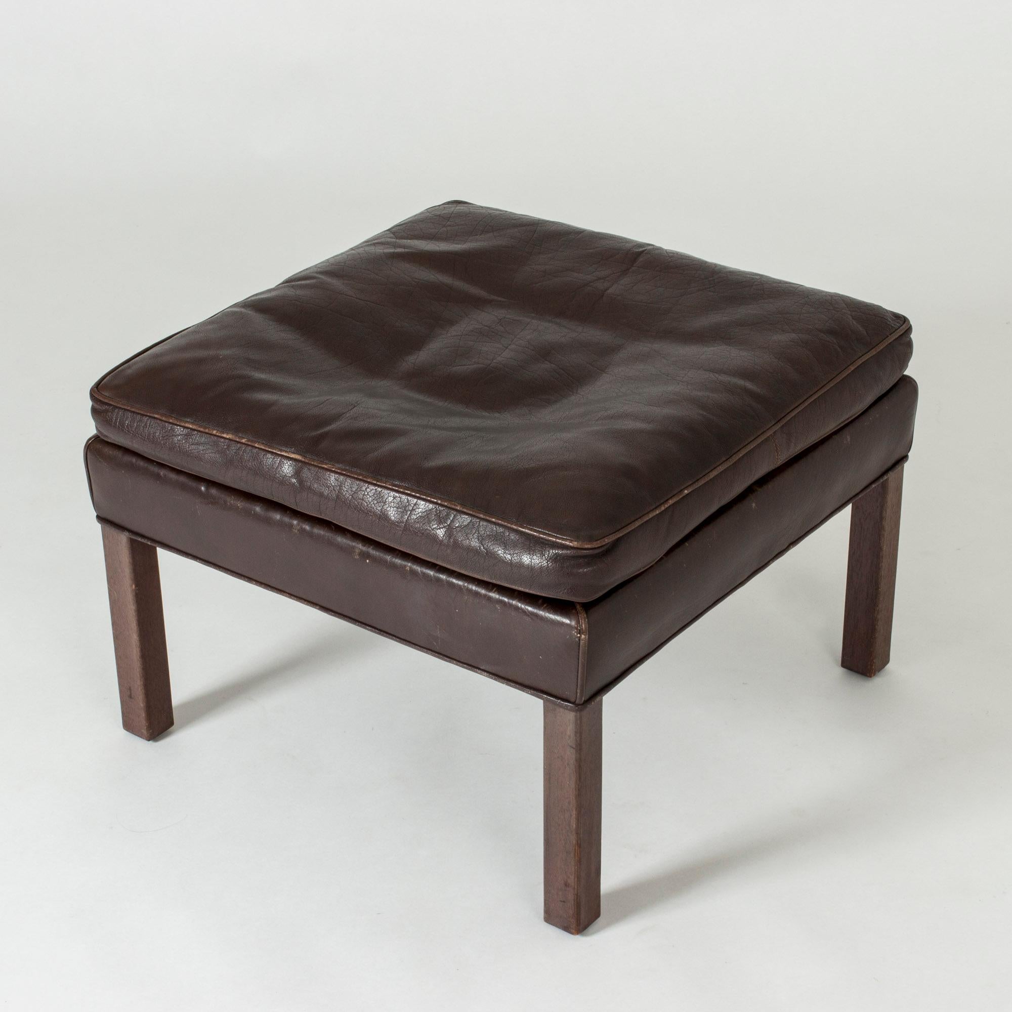 Elegant, timeless, comfortable leather ottoman by Børge Mogensen that can be combined with his sofas and armchairs or enjoyed by itself. Brown leather and rosewood legs.