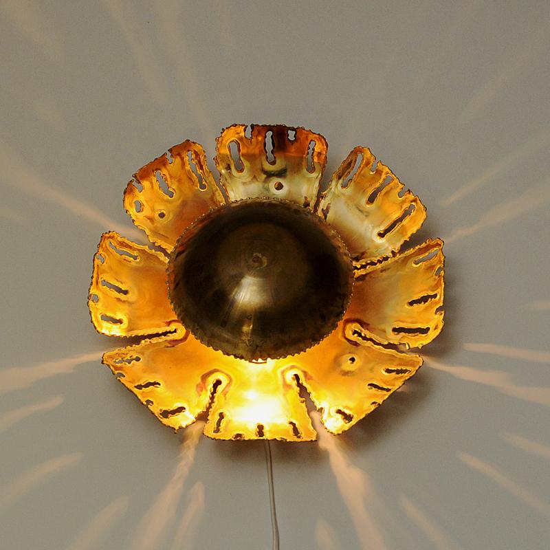 A lovely mid-century Danish brutalist wall lamp designed in the 1960s by designer Svend Aage Holm Sørensen for Holm Sørensen & Co AS, Denmark. This brass sconce has an acid-treated and torch-cut look in a brutalistic design. It gives a lovely and
