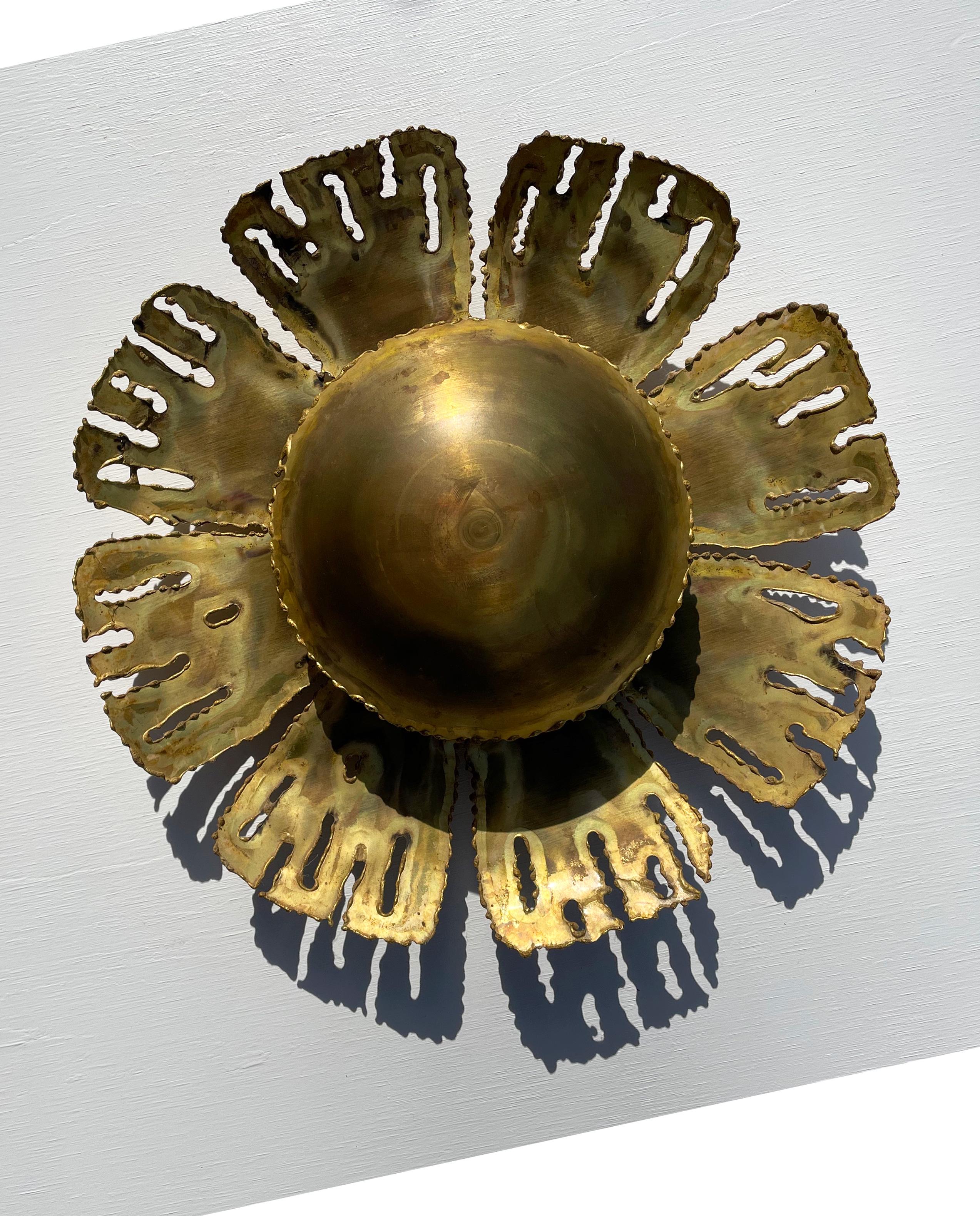 Danish Mid-Century Modern brutalist rustic brass wall light in the shape of a large flower with eight leaves surrounding a big round shiny center. Designed by the versatile Dane Svend Aage Holm Sørensen for his own company Holm Sørensen & Co. in the