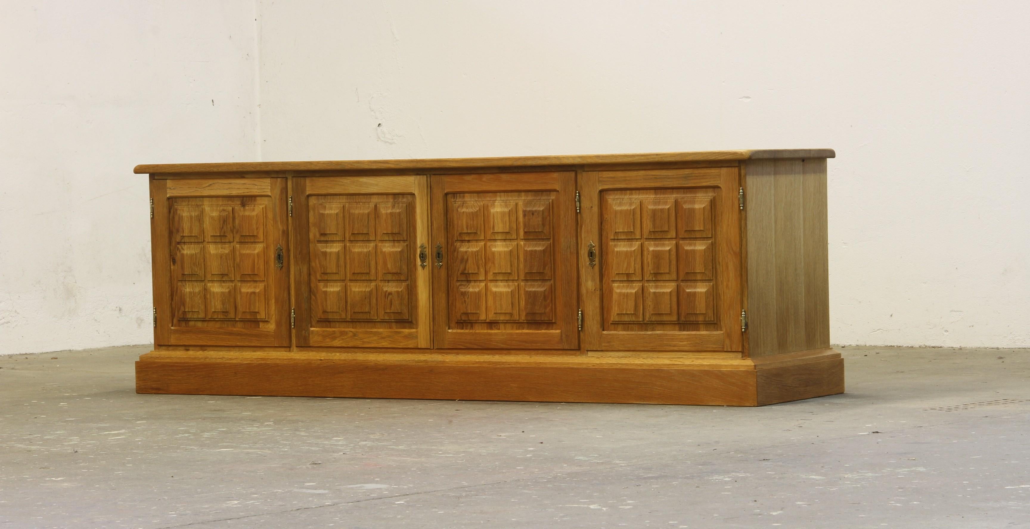 A Danish Mid-Century Modern low sideboard crafted from Nordic oak, designed and manufactured in Denmark during the 1960s/70s. This piece is often attributed to the esteemed Danish designer Henning (or Henry) Kjærnulf, renowned for his distinctive
